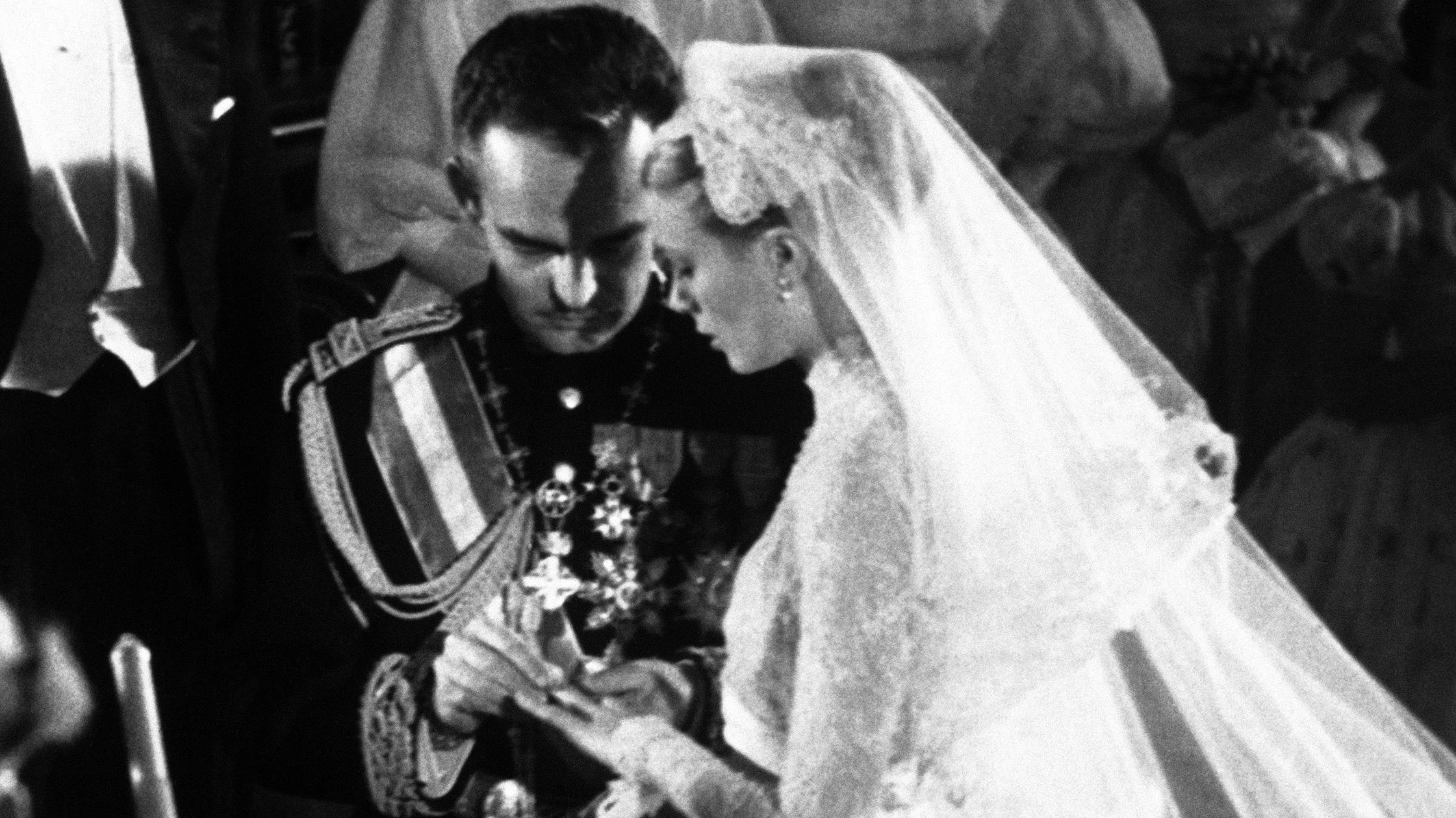 FILE - In this April 19, 1956 file photo, Prince Rainier places the ring on Grace Kelly's finger during their wedding ceremony in Monaco. Kelly retired from acting at 26 to become his princess, decamping to the tiny, well-heeled Mediterranean principality on the Riviera. (AP Photo, File)