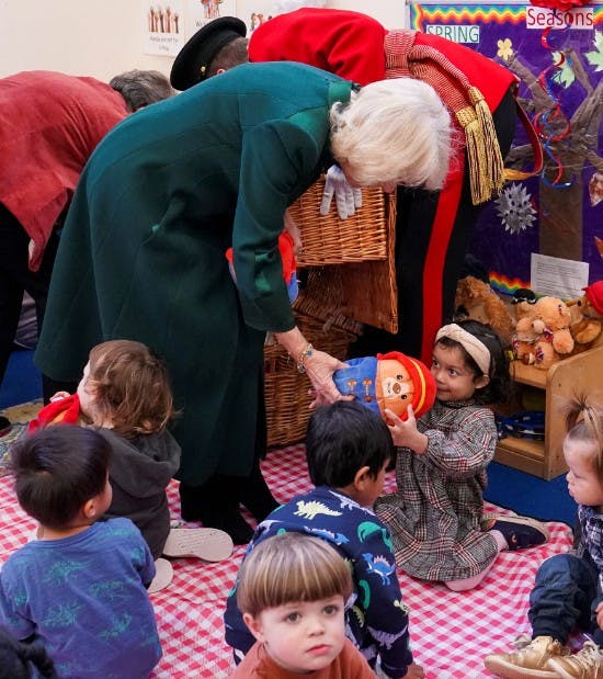 Dronning Camilla giver en lille pige en Paddington-bamse.&nbsp;

