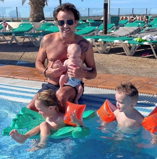 Dennis Knudsen i poolen med ferieglade børn