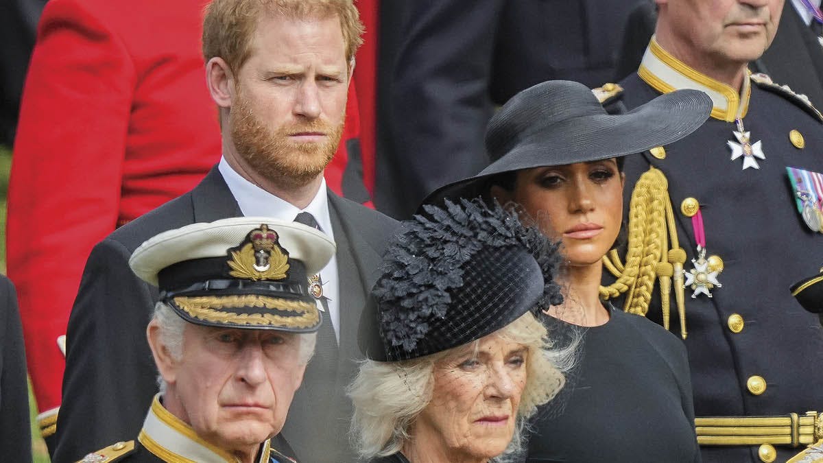 Kong Charles og dronning Camilla. I baggrunden prins Harry og hertuginde Meghan.
