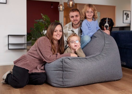 Familien hygger i stuen med hunden Otto i baggrunden.