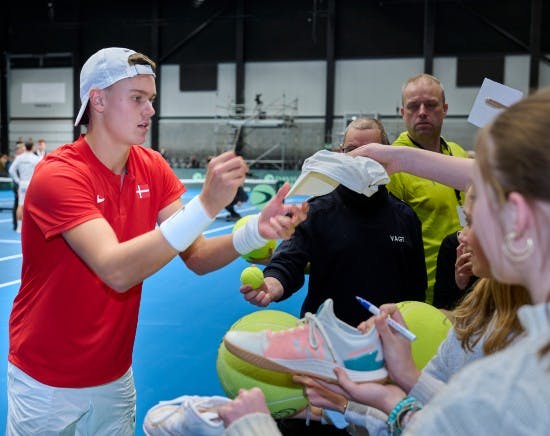 Holger Rune skriver autografer.