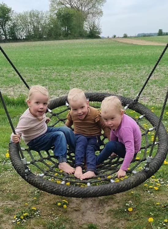 Her ses de tre trillinger midt i en gyngetur.