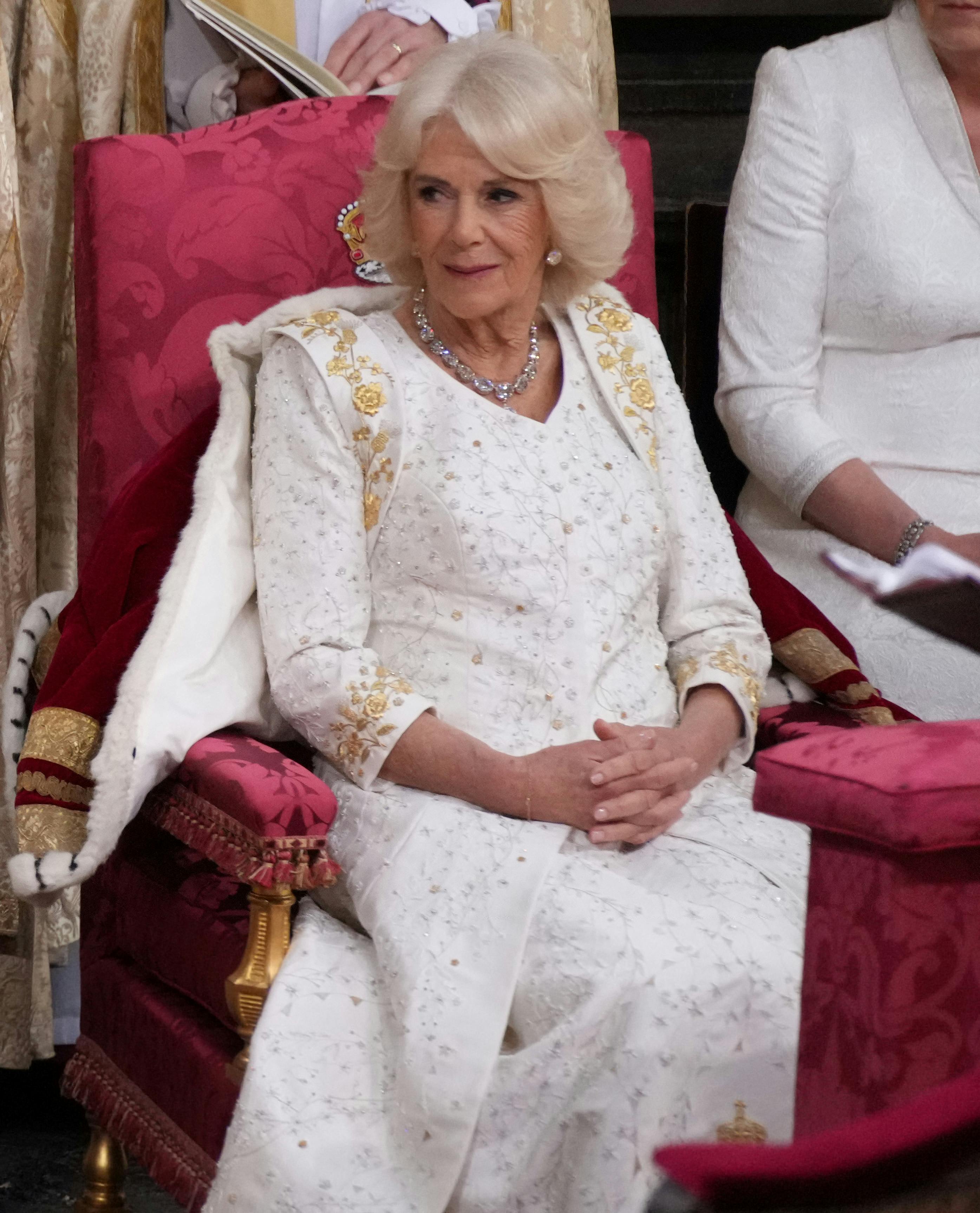 Dronning Camilla bar en lys kroningskjole med personlige detaljer broderet.&nbsp;
