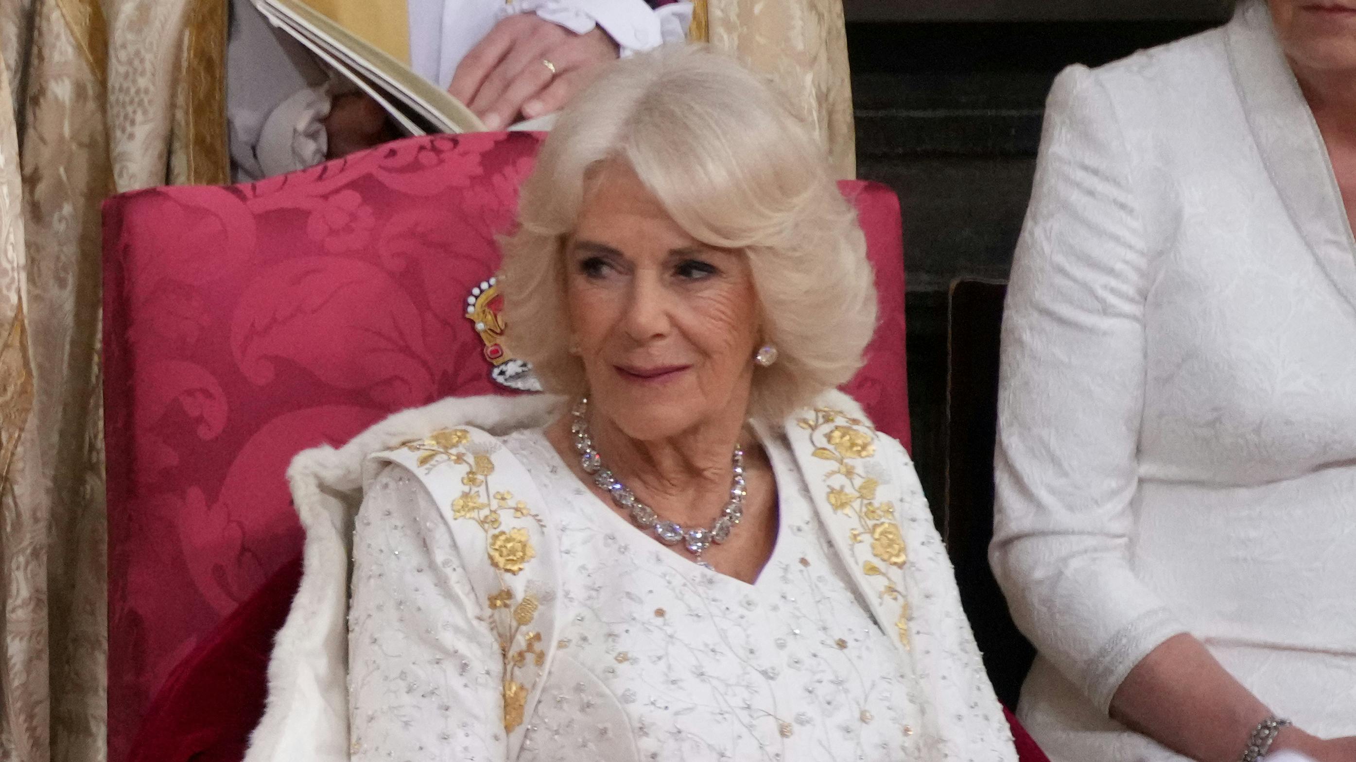 Dronning Camilla bar en lys kroningskjole med personlige detaljer broderet.&nbsp;
