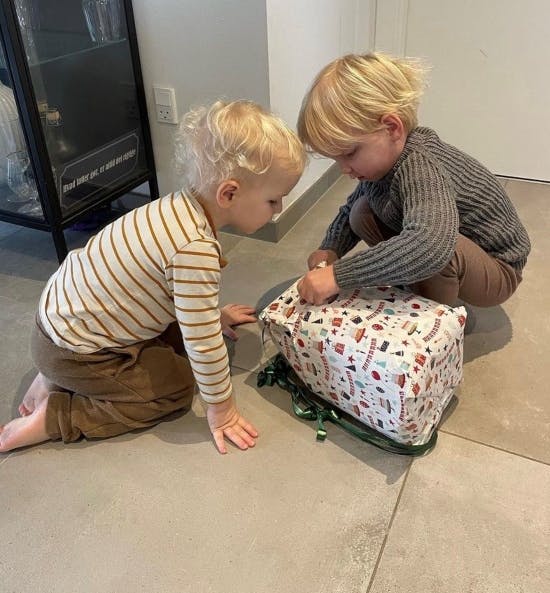 Lillebror Manfred hjælper Konrad med at pakke gaver op.