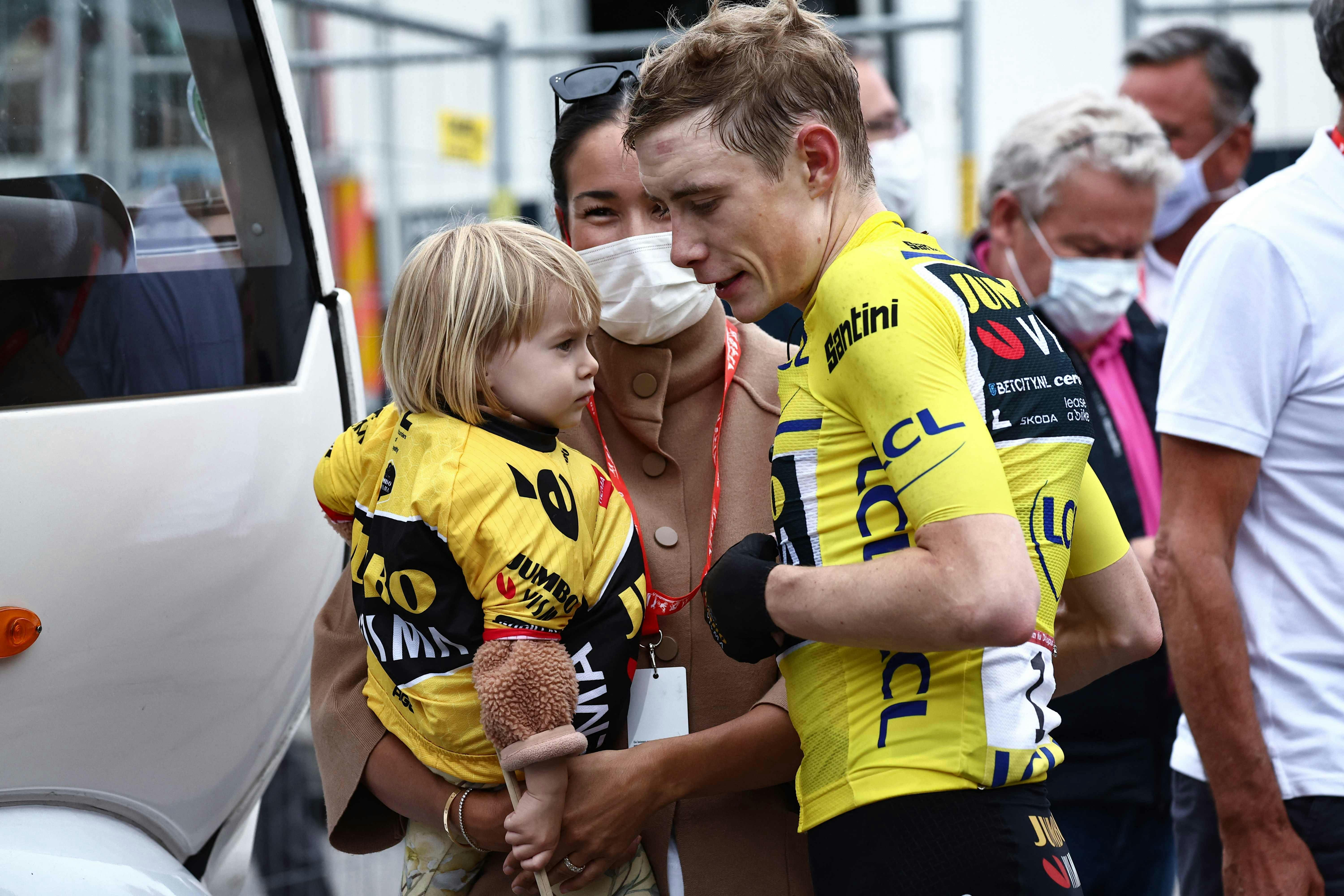 Wearing a Yellow Jersey of Overall Leader, Jumbo-Visma's Danish rider Jonas Vingegaard (R) talks to his partner Trine Marie Hansen (C) and their daughter Frida (L) after the sixth stage of the 75th edition of the Criterium du Dauphine cycling race, 170, 5km between Nantua to Crest-Voland, France, on June 9, 2023. (Photo by Anne-Christine POUJOULAT / AFP)