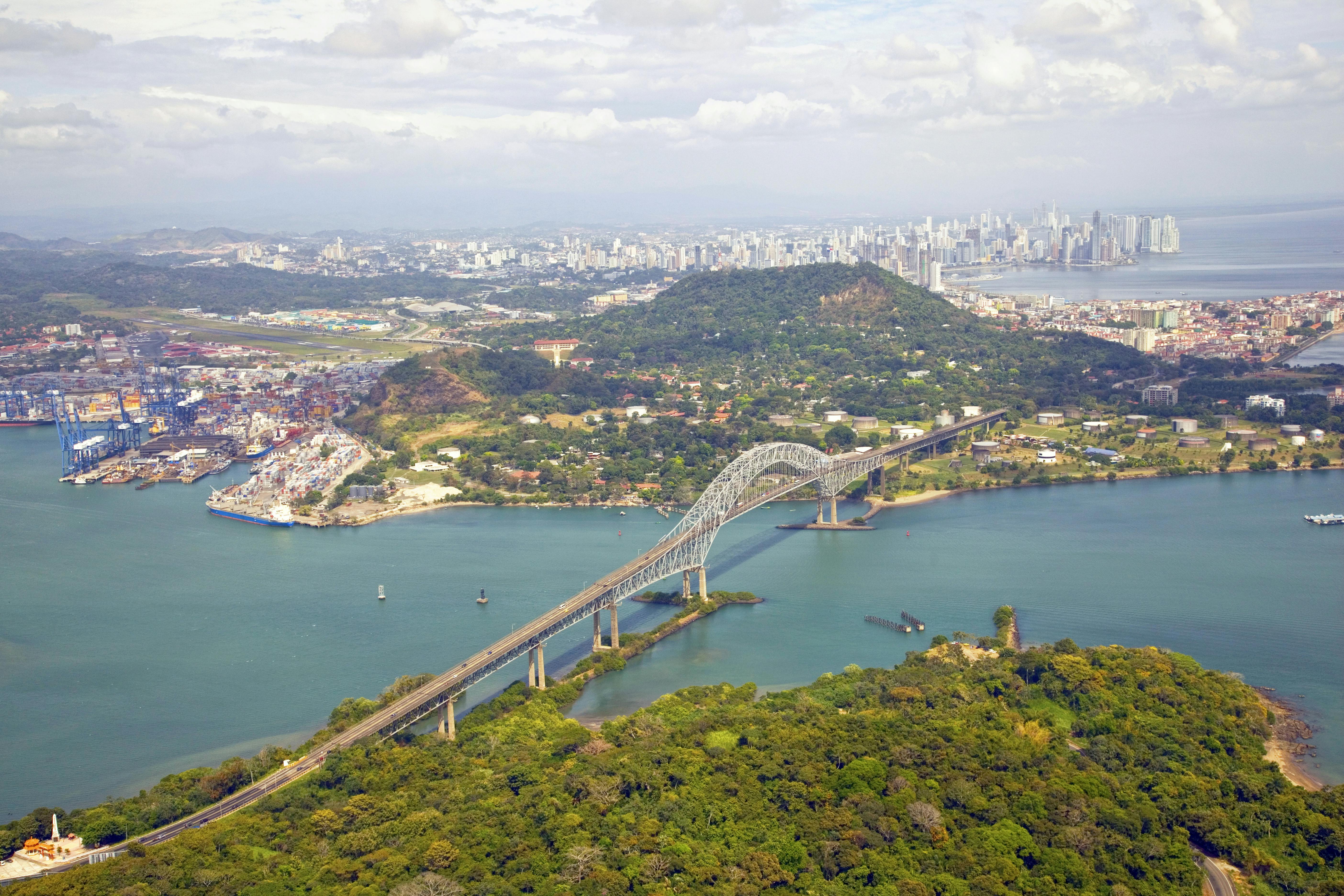 Aerial view of the Bridge of the Americas at the Pacific entrance to the Panama Canal with Panama City in the background.