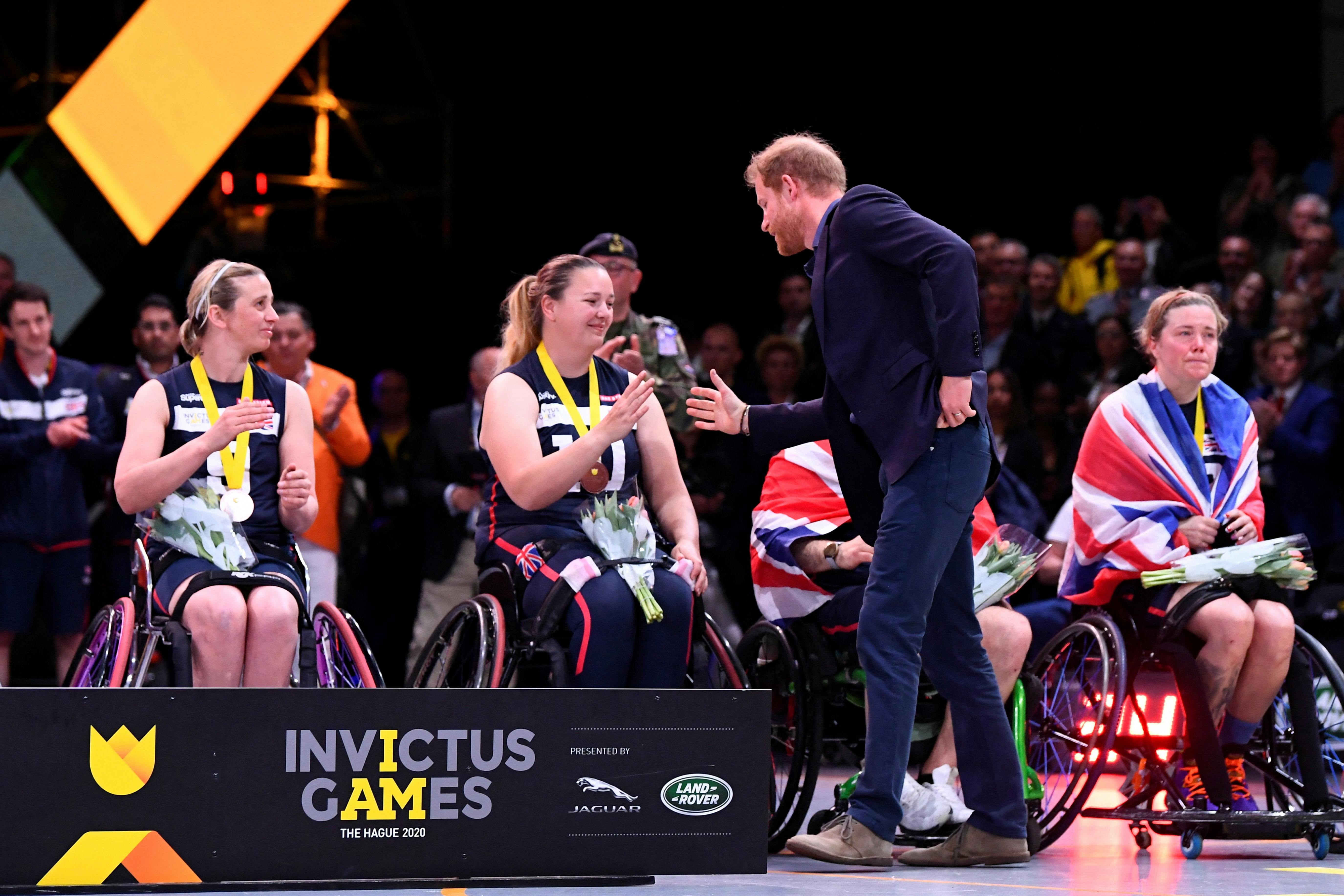 Britain's Prince Harry shakes hands with a British team member after the wheelchair basketball final of the Invictus Games in The Hague, Netherlands April 22, 2022. REUTERS/Piroschka Van De Wouw