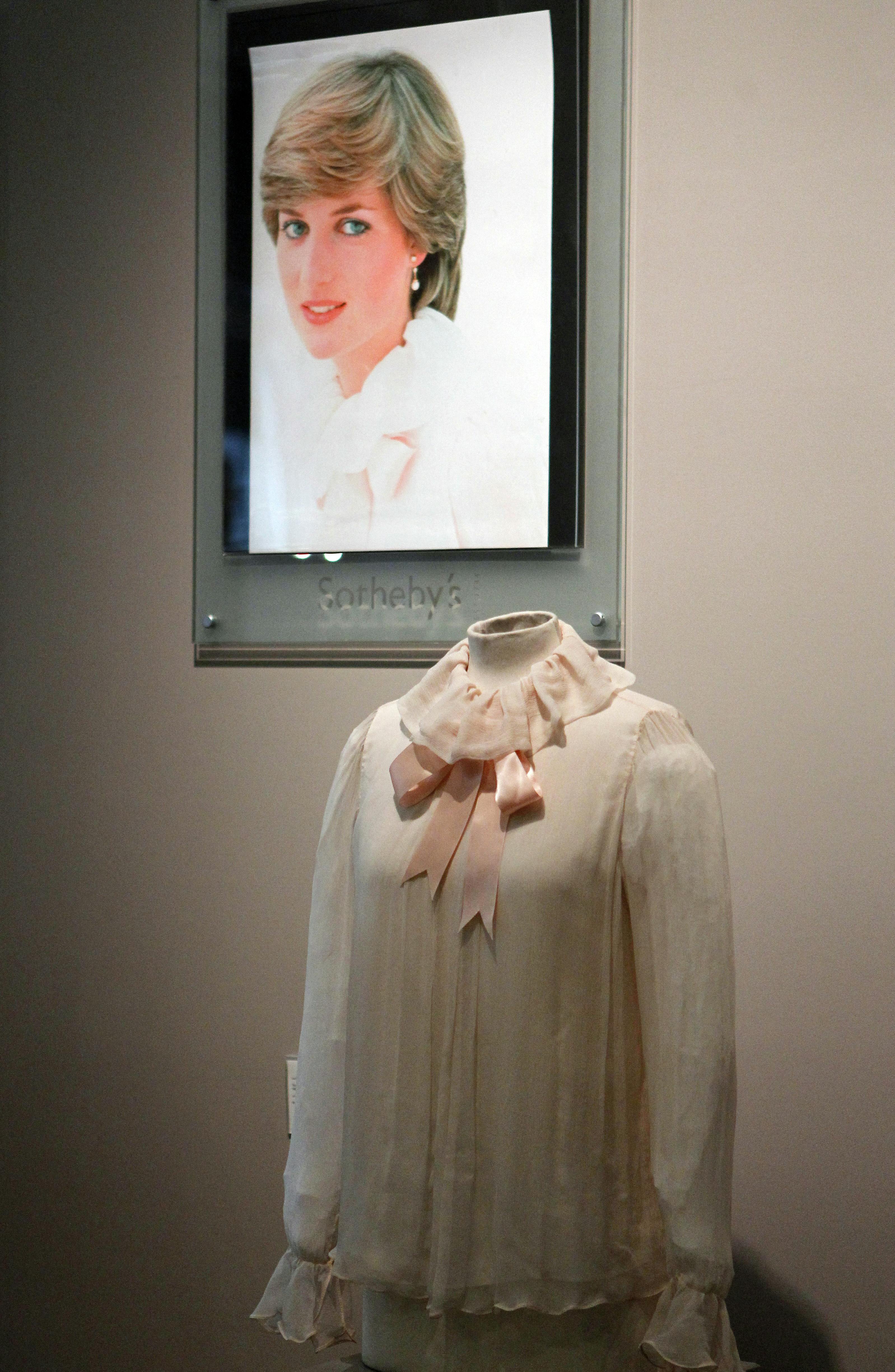 Skjorten, som sættes til salg på auktionen. Bagved skjortet ses portrættet af prinsesse Diana. 