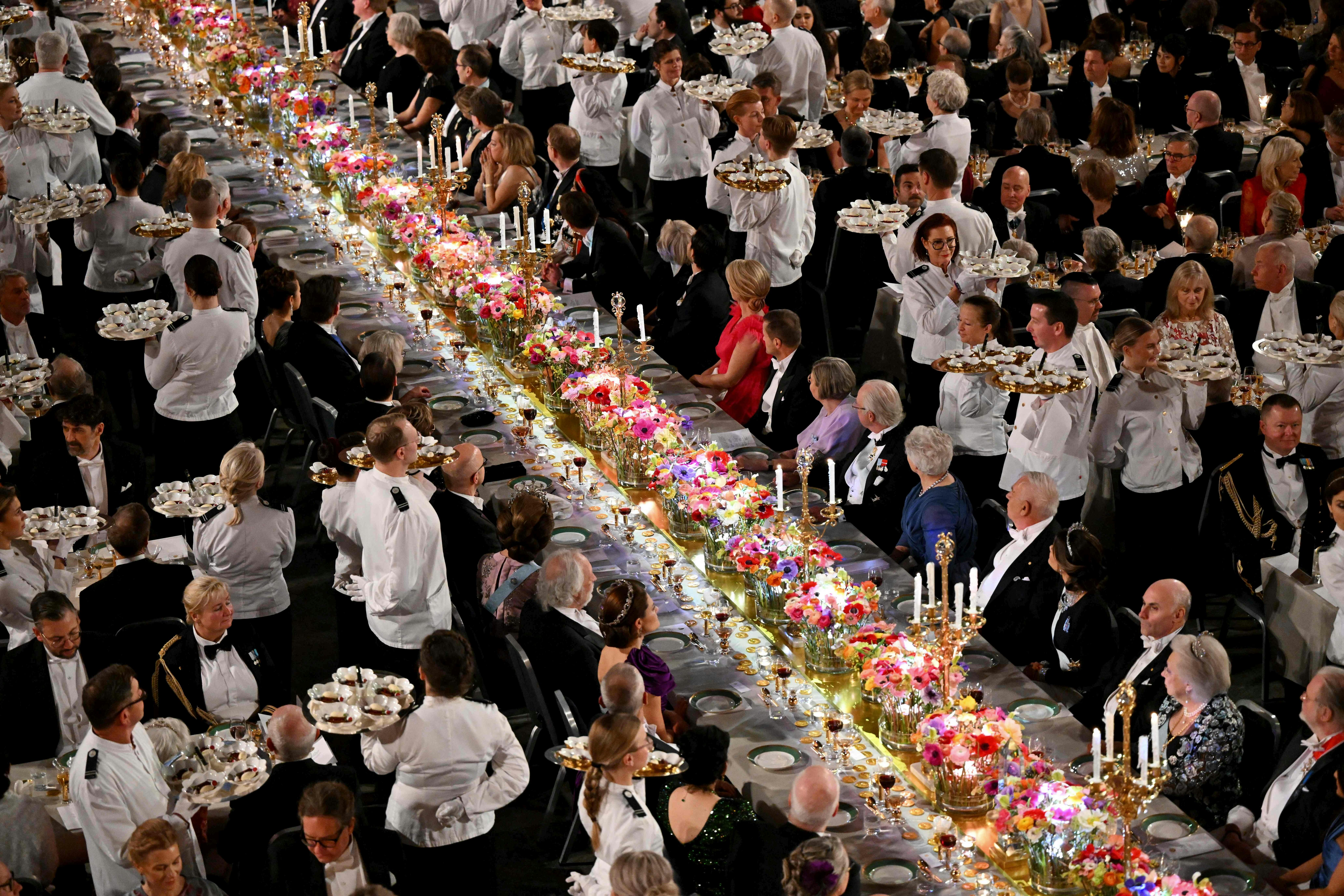 TOPSHOT - Waiters serve desserts during the Nobel Prize Banquet at the City Hall in Stockholm, Sweden on December 10, 2023, following the Nobel awards ceremony. (Photo by Jonathan NACKSTRAND / AFP)