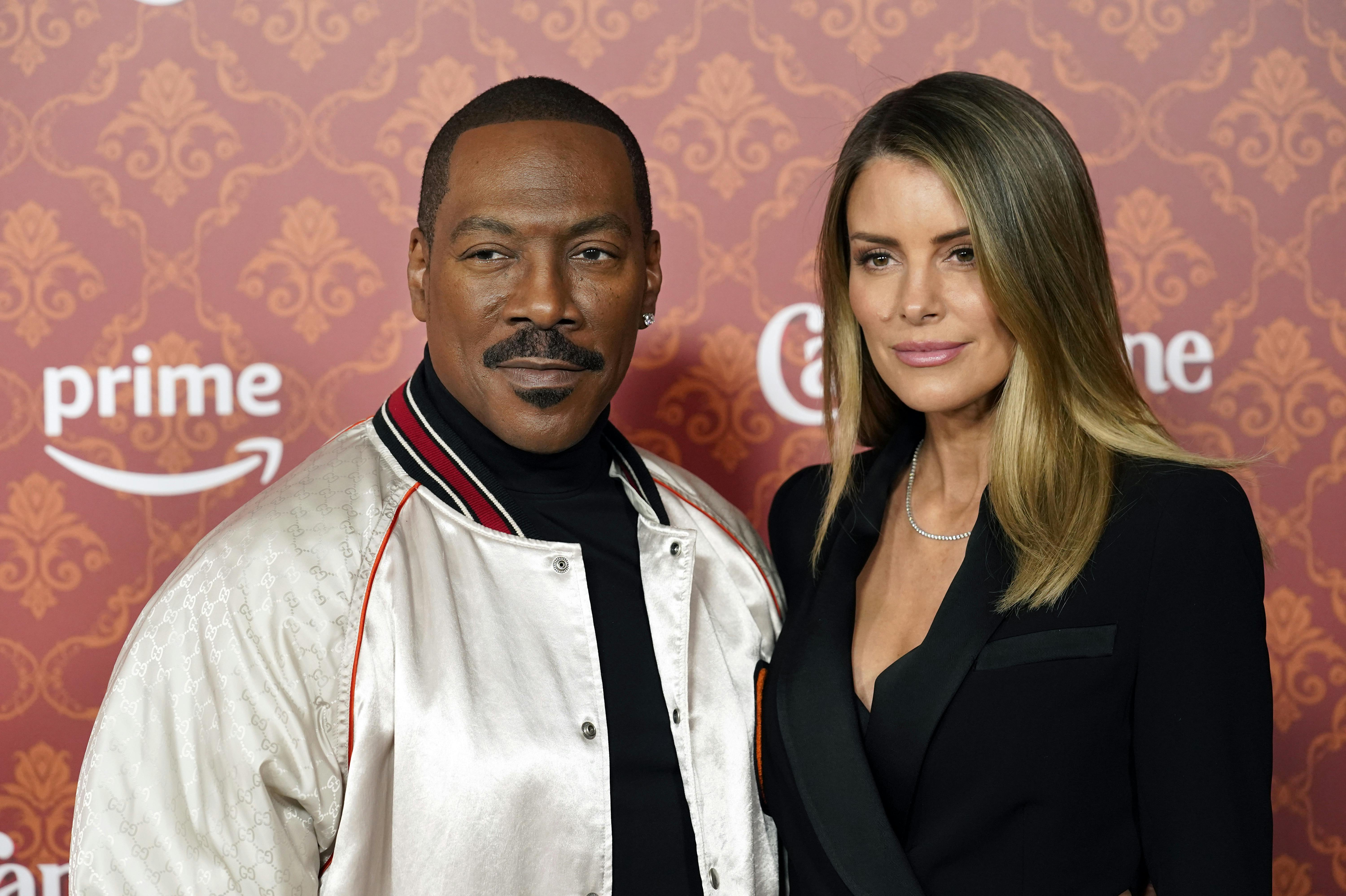Eddie Murphy and Paige Butcher pose together at the premiere of the film "Candy Cane Lane" at the Regency Village Theatre, Tuesday, Nov. 28, 2023, in Los Angeles. (AP Photo/Chris Pizzello)