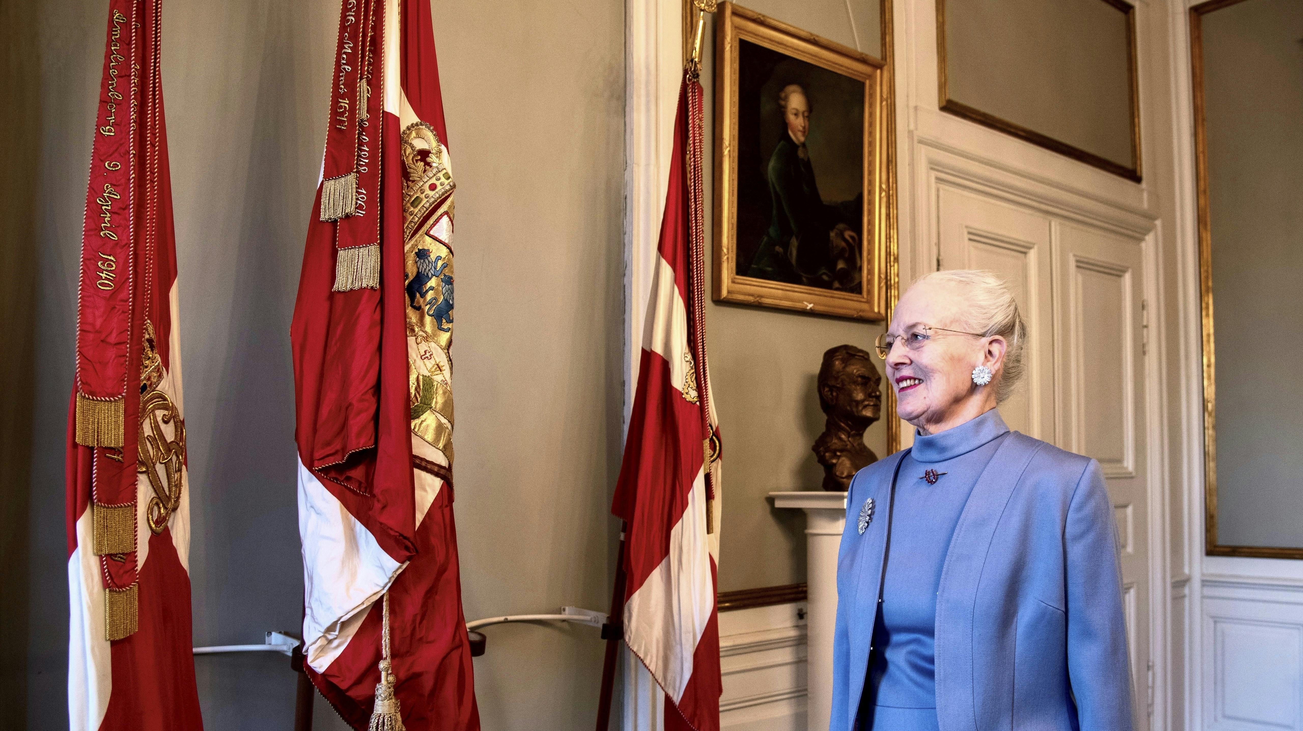 Dronning Margrethe foran de kongelige faner. 