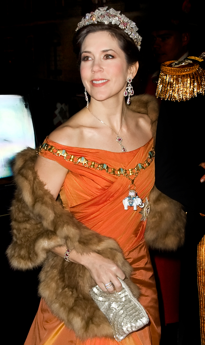 Dronningens Nytårskur - Nytårstaffel 2010 på Amalienborg - Kronprins Frederik og kronprinsesse Mary ankommer til Amalienborg. Kronprinsessen er i en ny orangegylden gallakjole designet af Jesper Høvring. Hertil diamant broche med rubiner, rubindiadem, halssmykke og øreringe, der har tilhørt dronning Ingrid - Dato: 01.01.2010 - Foto: Hanne Juul