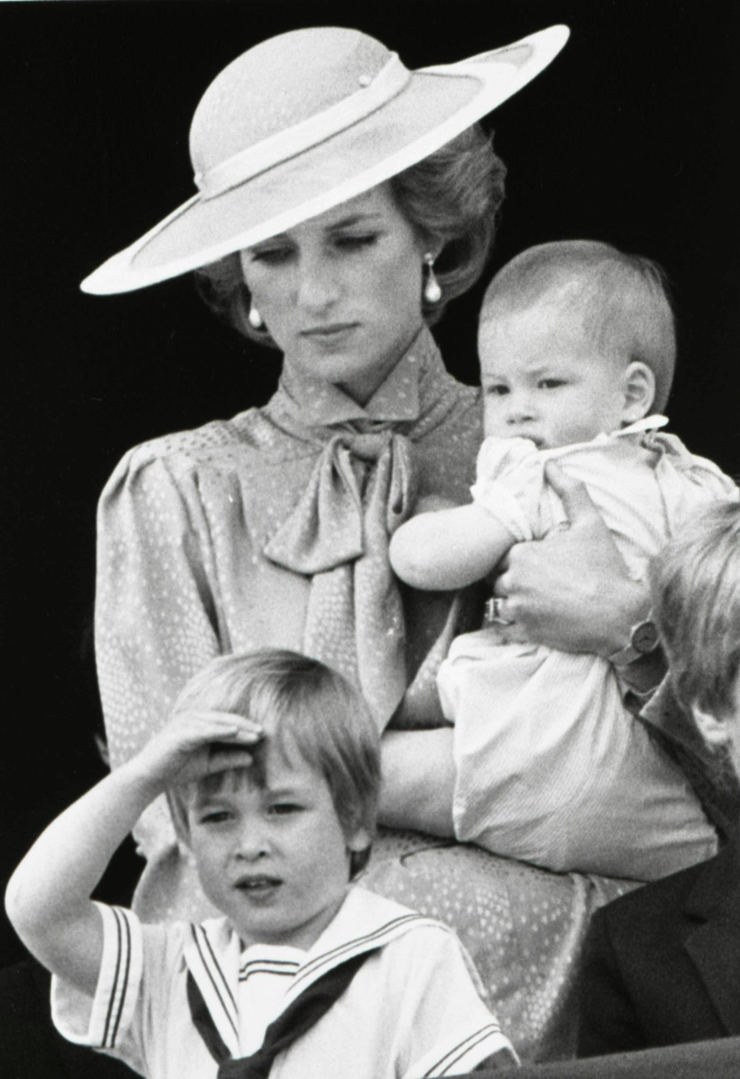 Prince William makes a royal salute as he watches the scene of Trooping the Colour from the balcony of Buckingham Palace with his brother Harry and mother Princess Diana on June 15, 1985 in London. REUTERS/Roy Letkey MAGDESK