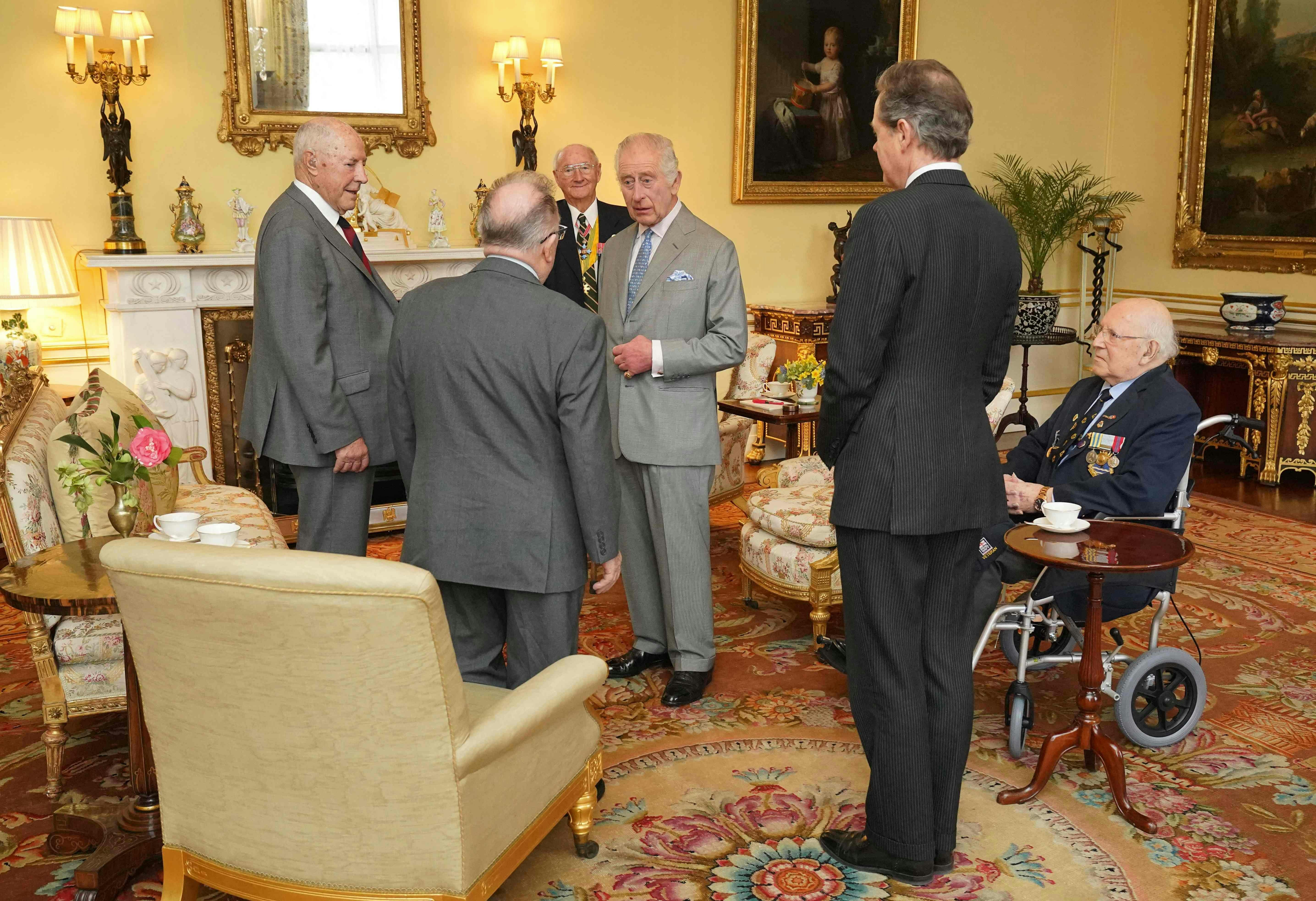 Britain's King Charles III (C) and Master of The King's Household, Vice Admiral Tony Johnstone-Burt (2R) talk with Veterans of the Korean War including Mike Mogridge (L), Alan Guy (2L), Brian Parritt (3L) and Ron Yardley during an audience at Buckingham Palace, in central London on March 19, 2024. (Photo by Jonathan Brady / POOL / AFP)