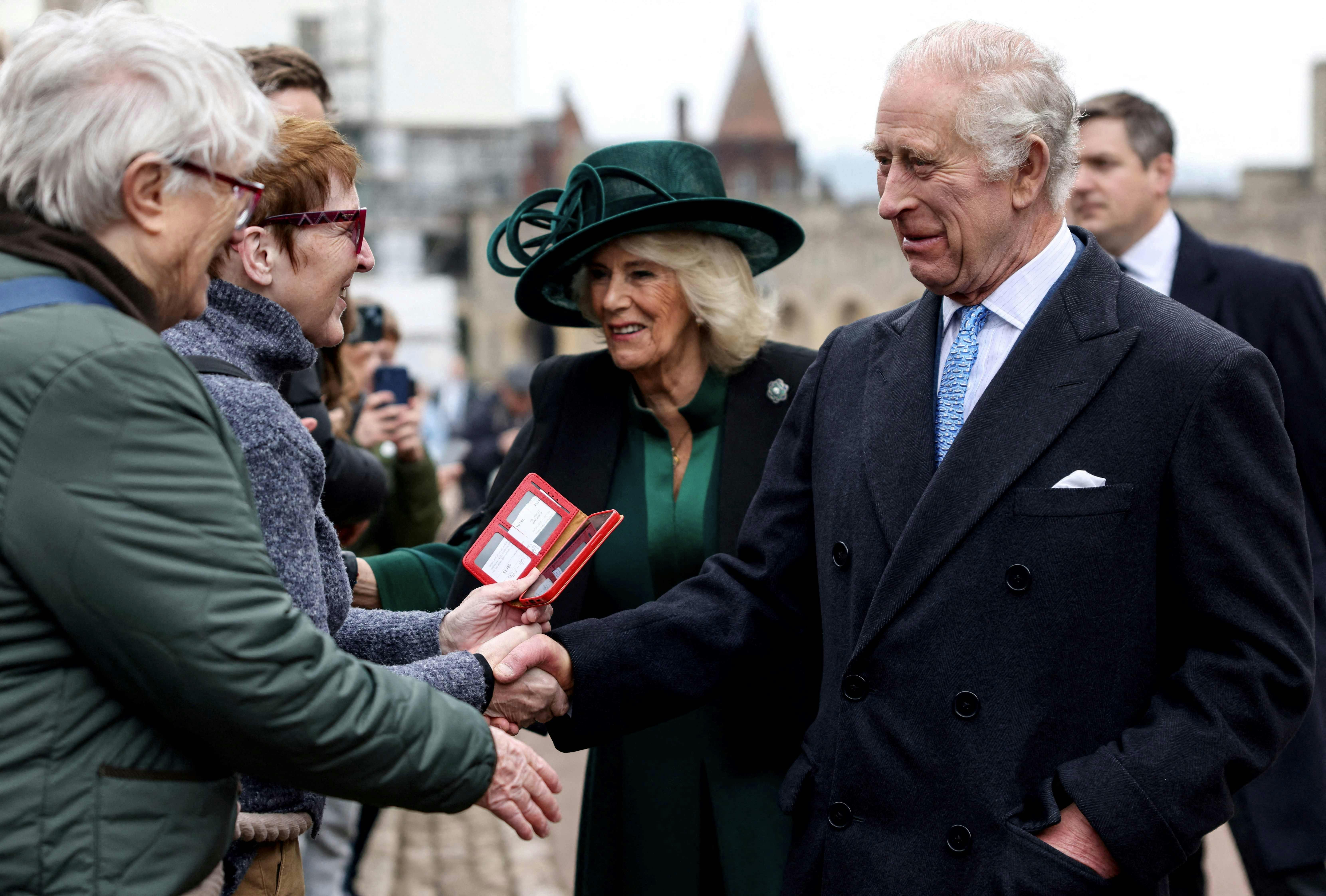 Britain's King Charles III (front R) and Britain's Queen Camilla (rear C) greet well-wishers as they leave St. George's Chapel, in Windsor Castle, after attending the Easter Mattins Service, on March 31, 2024. (Photo by Hollie Adams / POOL / AFP)