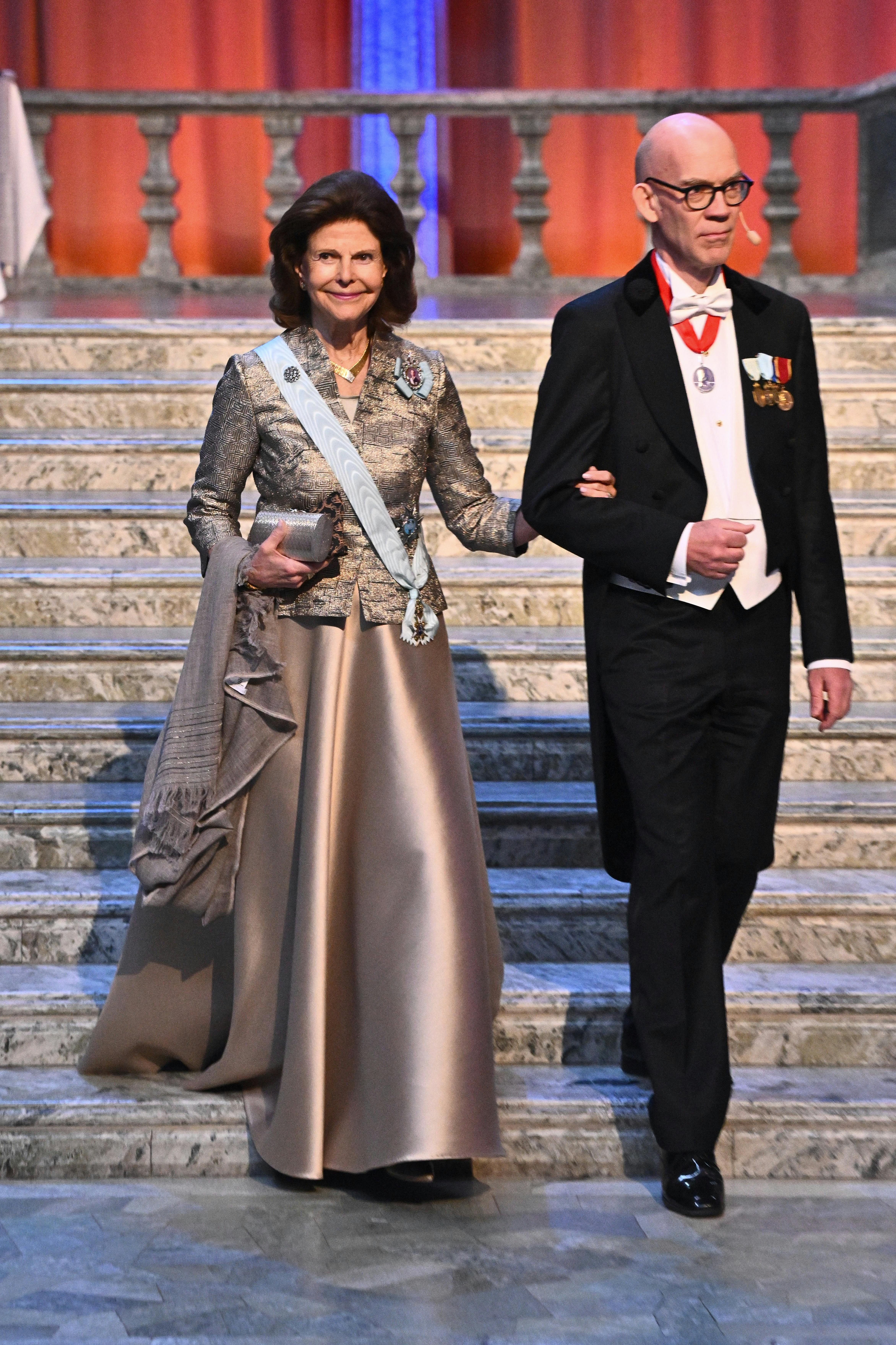 Sweden's Queen Silvia and the Academy's permanent secretary Hans Ellegren upon arrival at the Academy of Sciences' festive gathering in Stockholm City Hall on April 12, 2024. Photo: Claudio Bresciani / TT / Code 10090