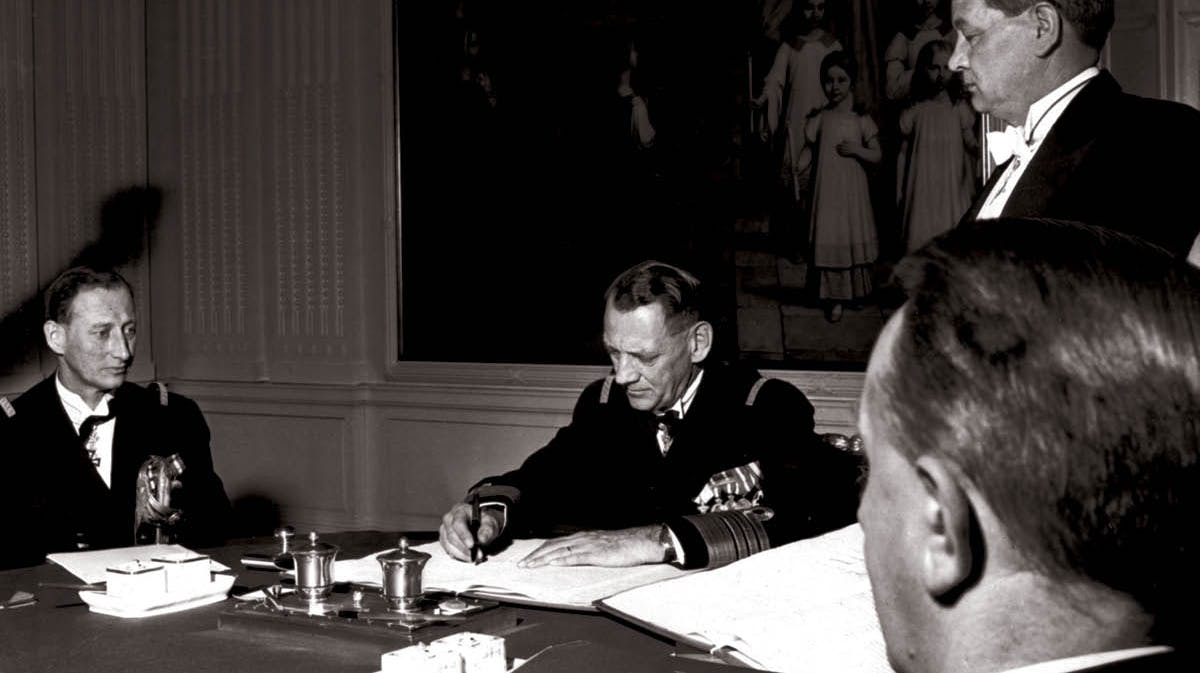 Frederik 9. underskriver den nye grundlov og tronfølgelov i 1953 med arveprins Knud og statsminister Erik Eriksen ved sin side.