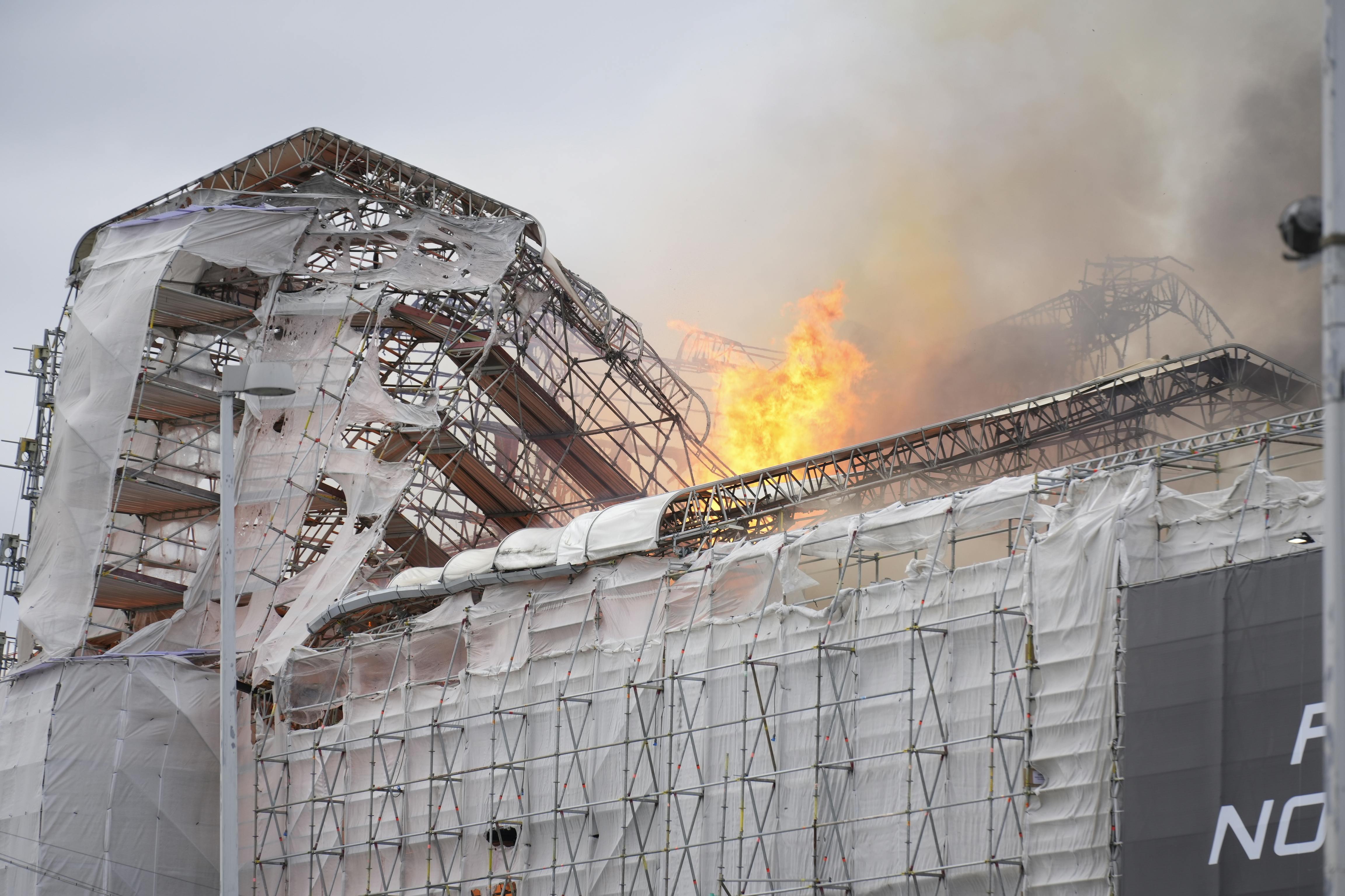 Børsen og bygningens spir er totalt opslugt af røg og kraftige flammer fra en brand i København tirsdag den 16. april 2024.