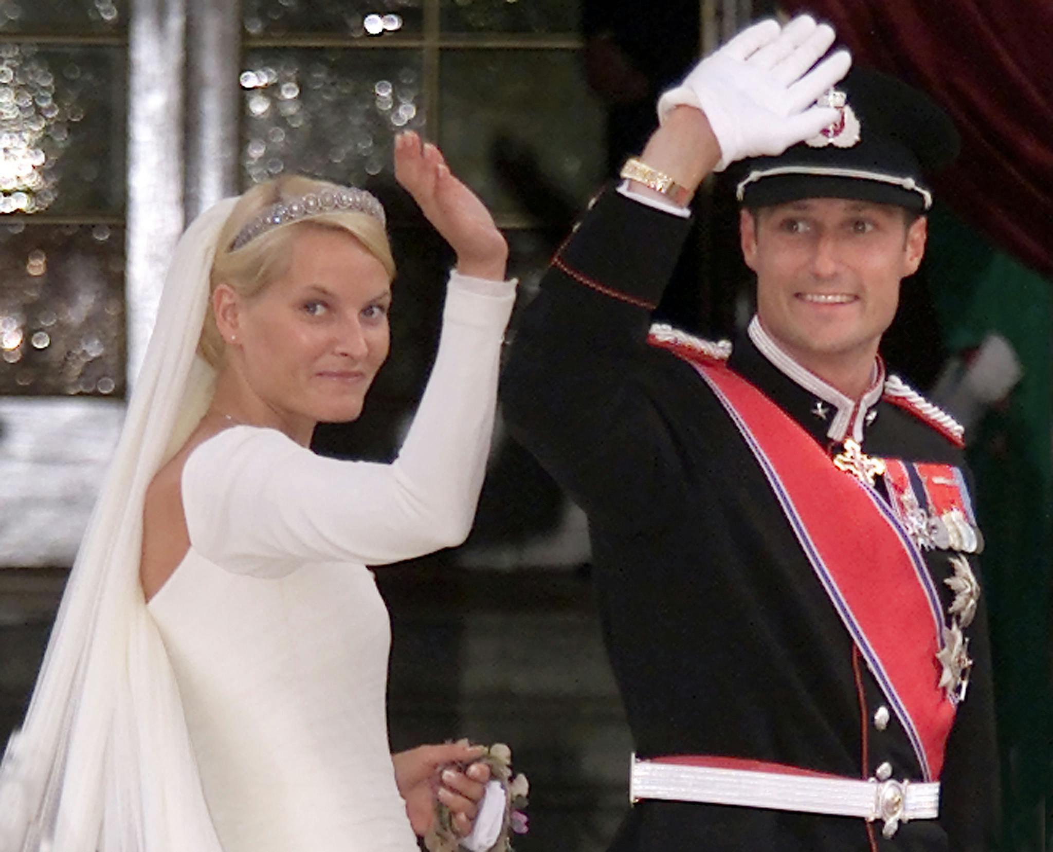 Norway's Crown Prince Haakon and his fiancee Mette-Marit Tjessem Hoiby (L) wave to well wishers as they arrive for their wedding at the Oslo Cathedral August 25, 2001. Thousands of people thronged the streets of Oslo on Saturday to cheer Norway's Crown Prince Haakon and the controversial single-mother Cinderella he will wed later in the day. REUTERS/Christian Charisius. (Foto: CHRISTIAN CHARISIUS/SCANPIX NORDFOTO 2001)