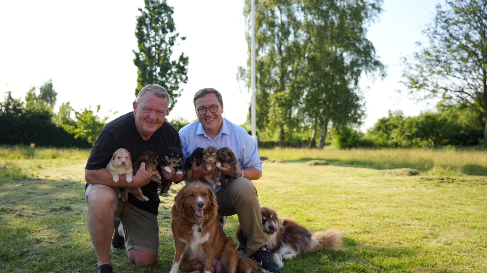 Lars og Bergur Løkke Rasmussen med de nye hvalpe. Mor Frida i midten er Lars' hund, mens Bergurs Atlas gemmer sig bag hans ben. 