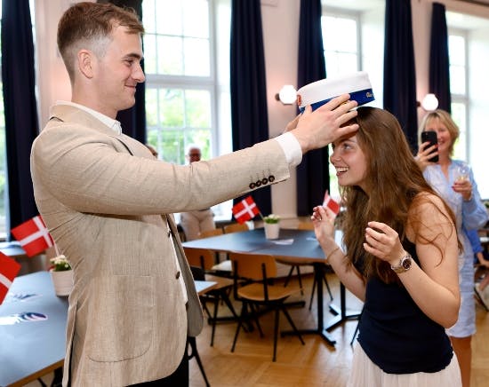 Storebror Julius sætter studenterhuen på Clara.