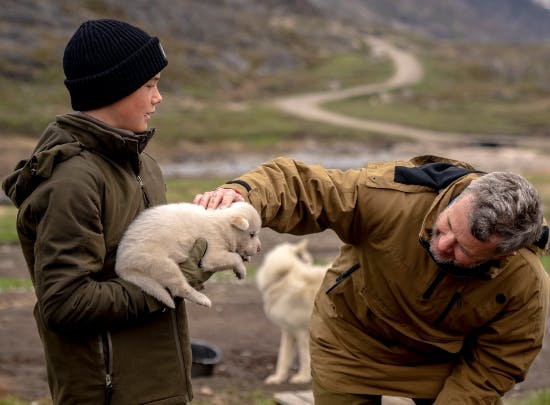Prins Vincent og kong Frederik X med slædehundehvalpen Emil i Hundebyen.