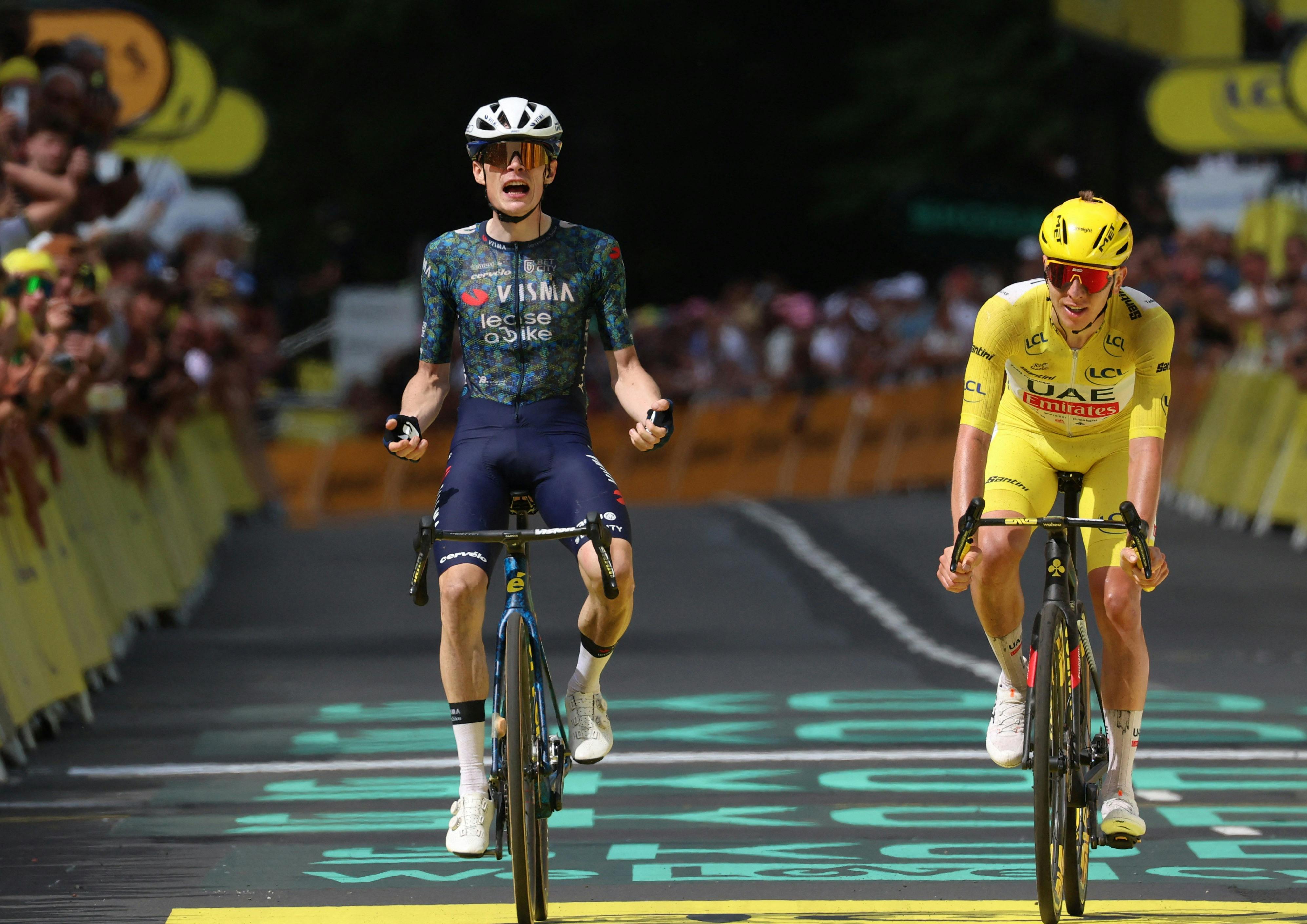 Cycling - Tour de France - Stage 11 - Evaux-les-Bains to Le Lioran - Evaux-les-Bains, France - July 10, 2024 Team Visma Lease a Bike's Jonas Vingegaard celebrates winning stage 11 alongside second place UAE Team Emirates' Tadej Pogacar REUTERS/Molly Darlington