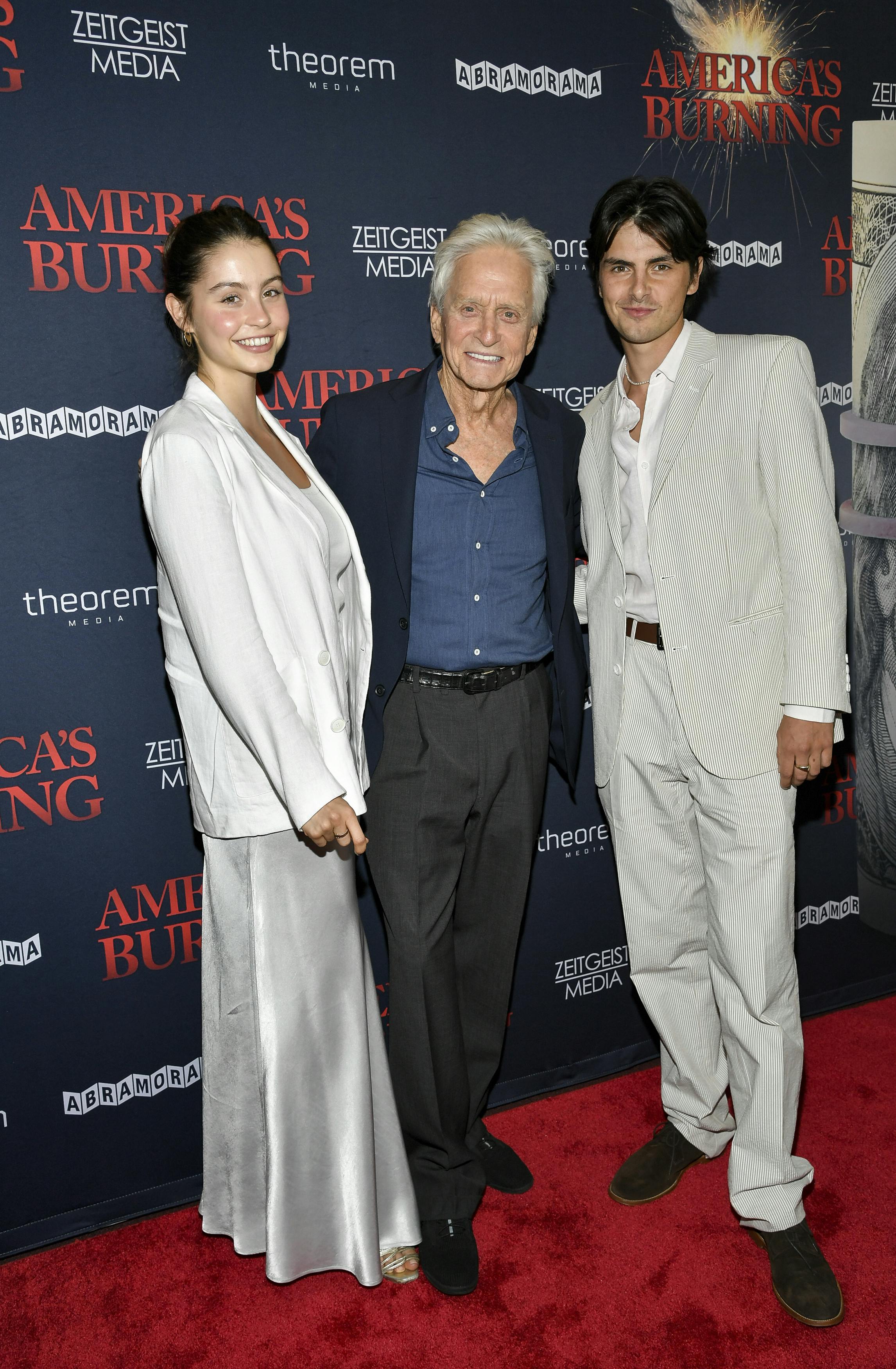 Executive producer Michael Douglas, center, poses with his daughter Carys Douglas, left, and son Dylan Douglas at a special screening of "America's Burning" at the DGA New York Theater on Wednesday, July 10, 2024, in New York. (Photo by Evan Agostini/Invision/AP)