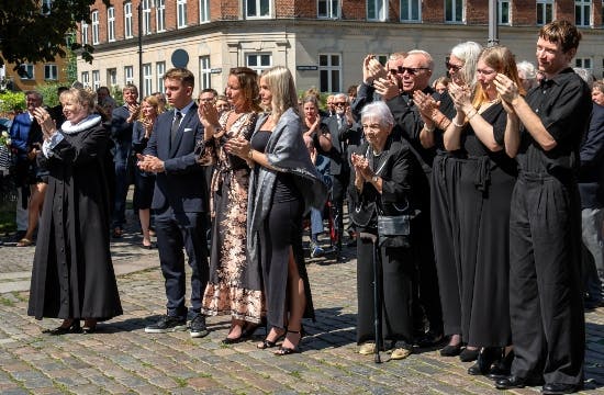 Deltagerne ved Jens Werners bisættelse klapper Jens Werners kiste afsted fra kirken. 