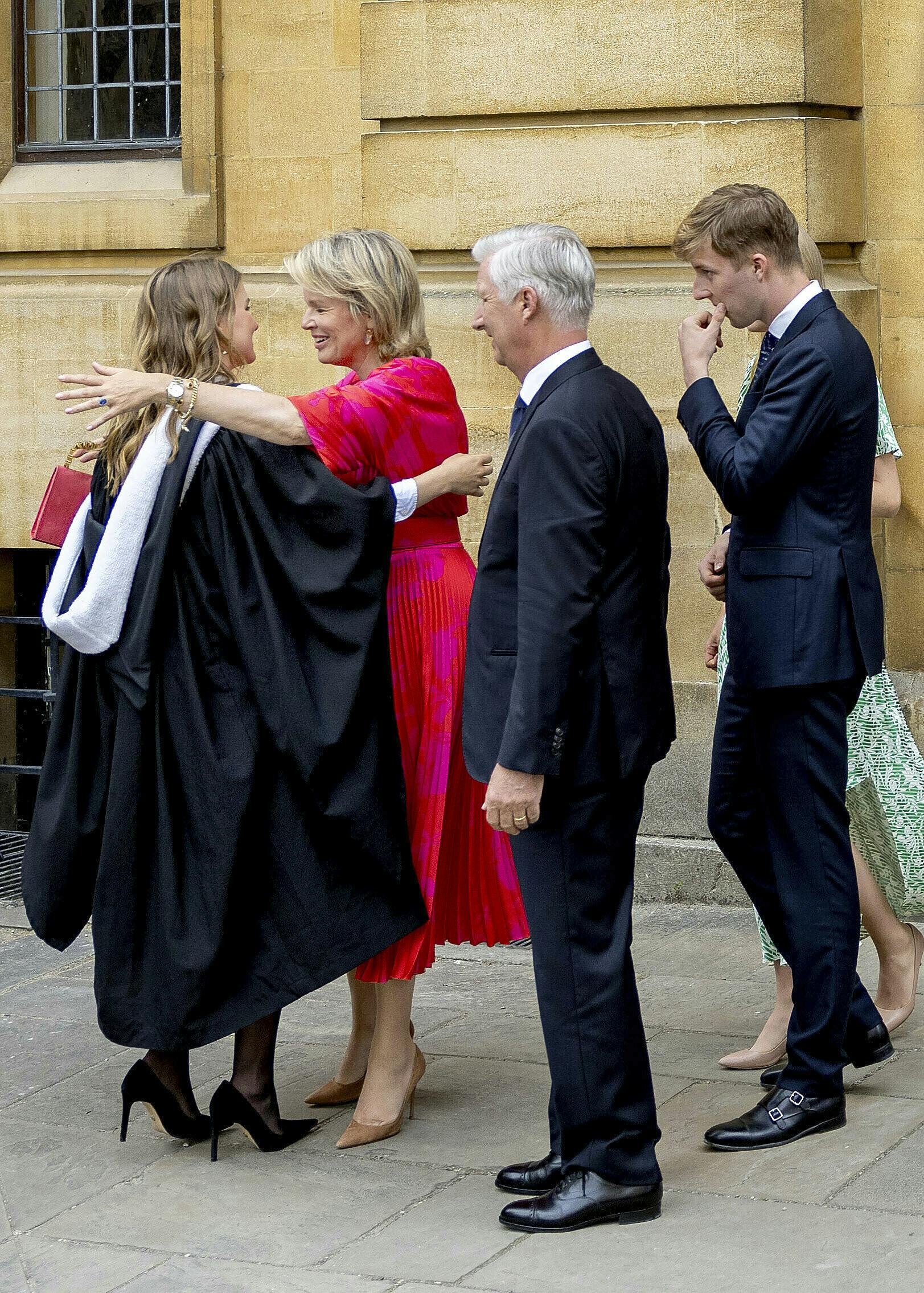 Dronning Mathilde i rødt omfavner prinsesse Elisabeth.