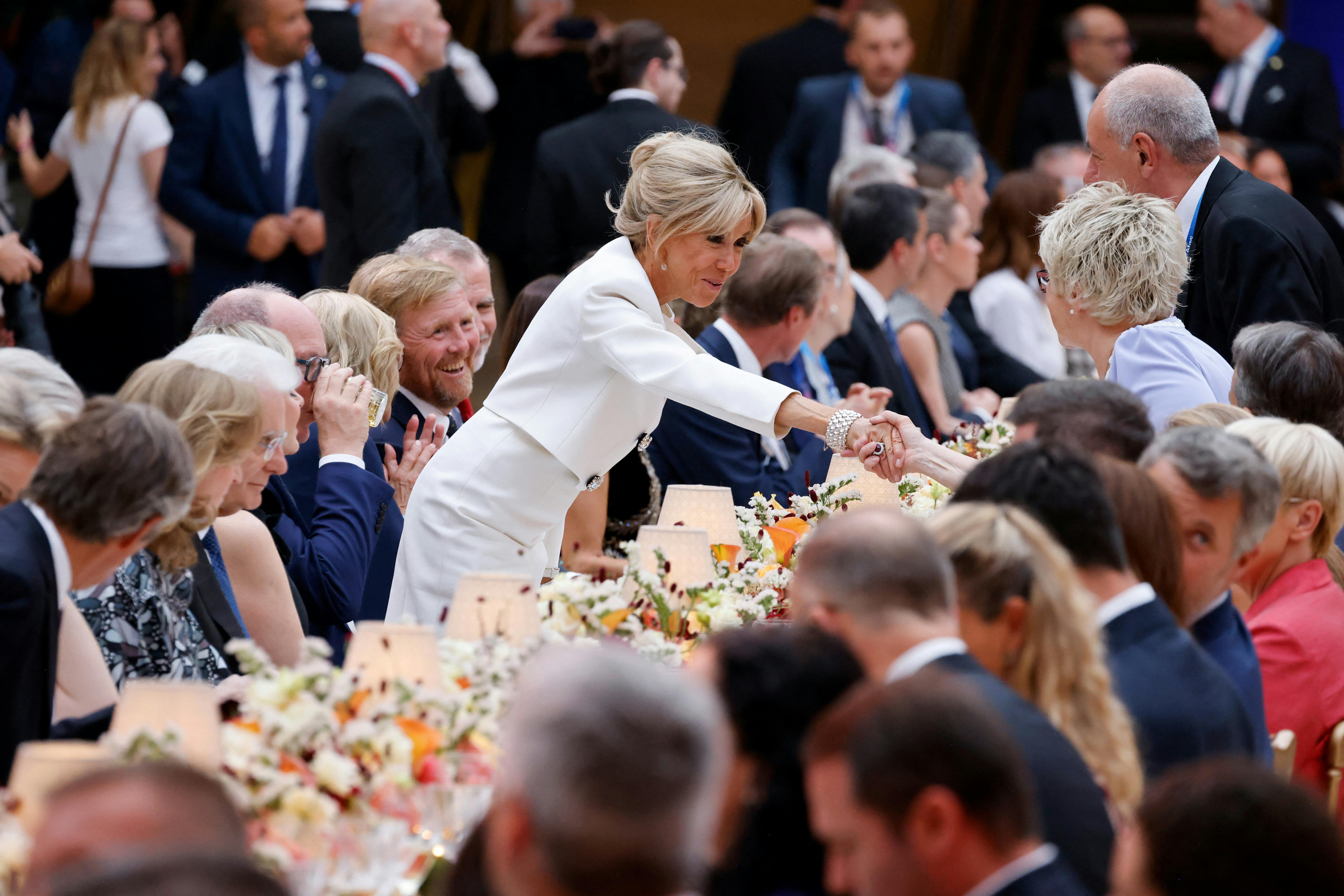 French President's wife Brigitte Macron greets guests during a gala dinner hosted by the International Olympic Committee (IOC) and the French Presidency at the Louvre Museum in Paris, on the eve of the opening ceremony of the Paris 2024 Olympic Games, July 25, 2024. Ludovic Marin/Pool via REUTERS