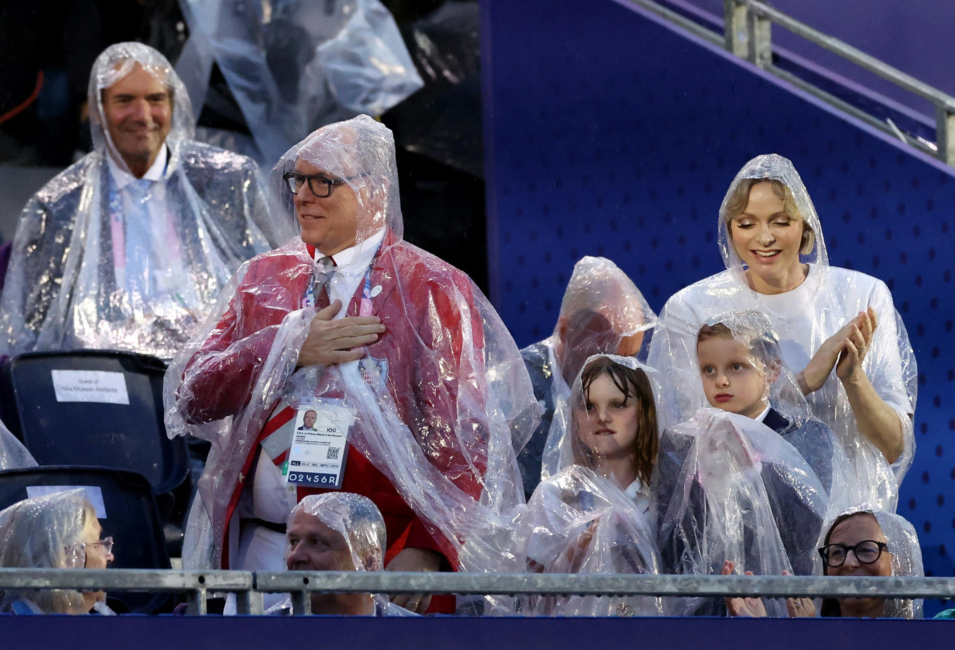 Paris 2024 Olympics - Opening Ceremony - Paris, France - July 26, 2024. Prince Albert II of Monaco and Princess Charlene of Monaco, Princess Gabriella, Countess of Carlades, and Jacques, Hereditary Prince of Monaco are seen wearing rain coats during the opening ceremony of the Paris 2024 Olympics.