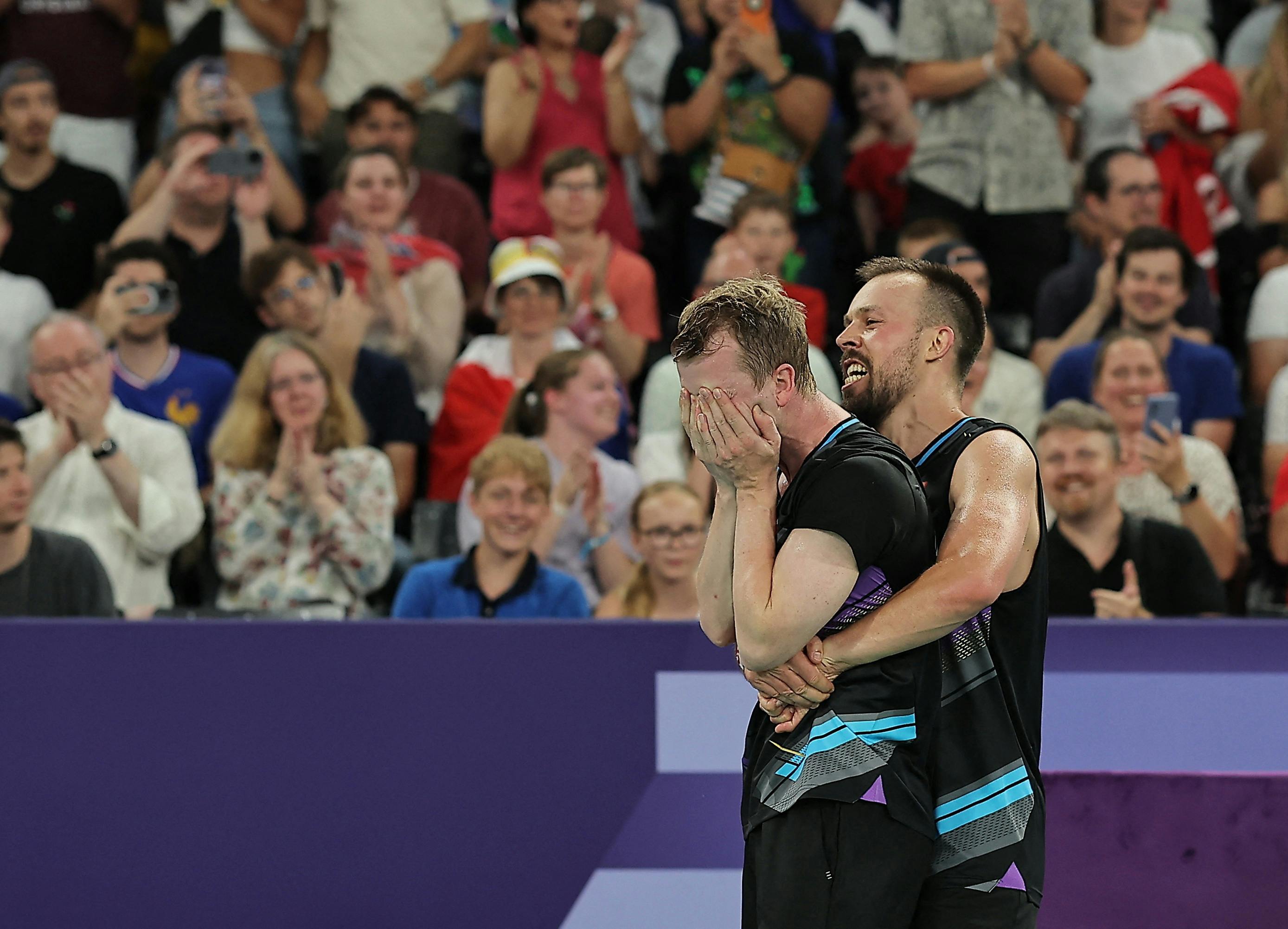 Paris 2024 Olympics - Badminton - Men's Doubles Quarterfinals - Porte de La Chapelle Arena, Paris, France - August 01, 2024. Anders Skaarup Rasmussen of Denmark and Kim Astrup of Denmark hug after winning the match against Min Hyuk Kang of South Korea and Seung Jae Seo of South Korea. REUTERS/Ann Wang