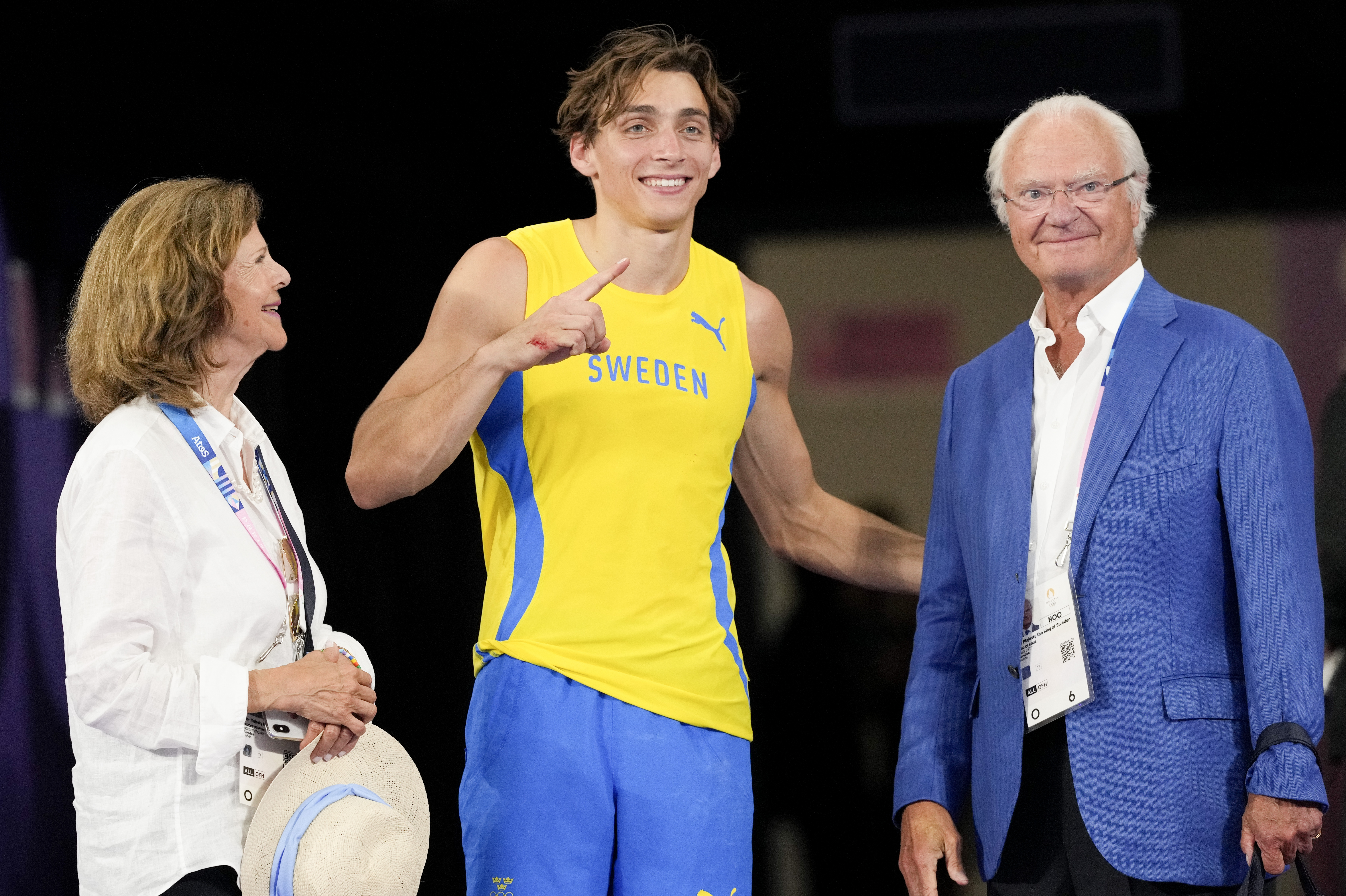 Armand Duplantis, of Sweden, meets with Carl Gustaf Folke Hubertus, King of Sweden and his wife Silvia, after setting a new world record in the men's pole vault final at the 2024 Summer Olympics, Monday, Aug. 5, 2024, in Saint-Denis, France. (AP Photo/Bernat Armangue)