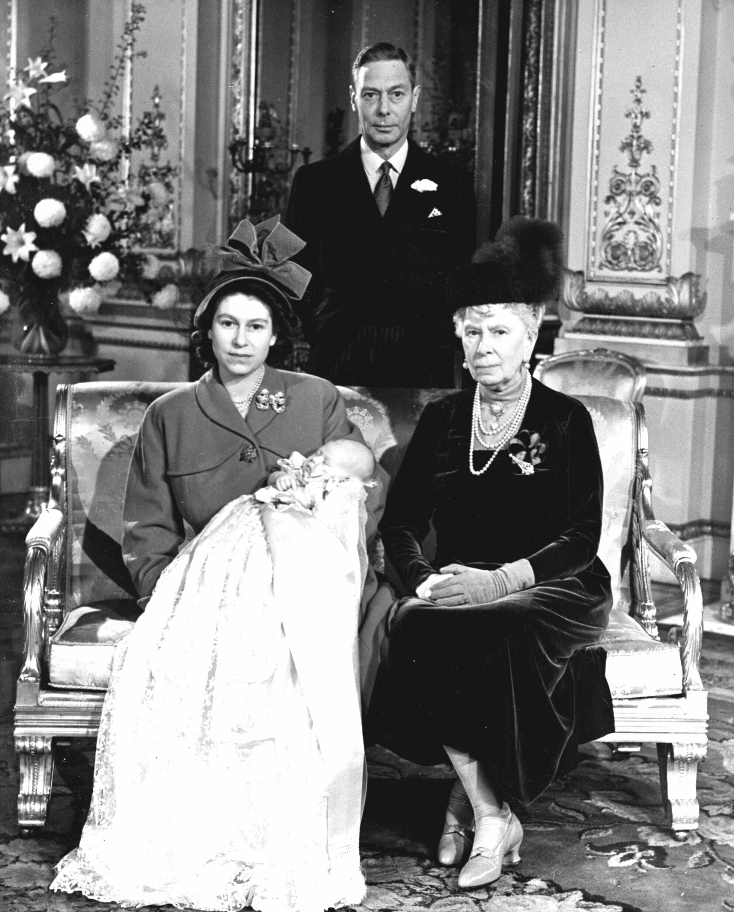 FILE - In this Dec .15, 1948 file photo, Britain's Princess Elizabeth, later Queen Elizabeth II, holds her son Prince Charles at Buckingham Palace, following his christening. Seated at right is Queen Mary, the mother of King George VI, background. Queen Elizabeth II, Britain's longest-reigning monarch and a rock of stability across much of a turbulent century, has died. She was 96. Buckingham Palace made the announcement in a statement on Thursday Sept. 8, 2022. (AP Photo, File)