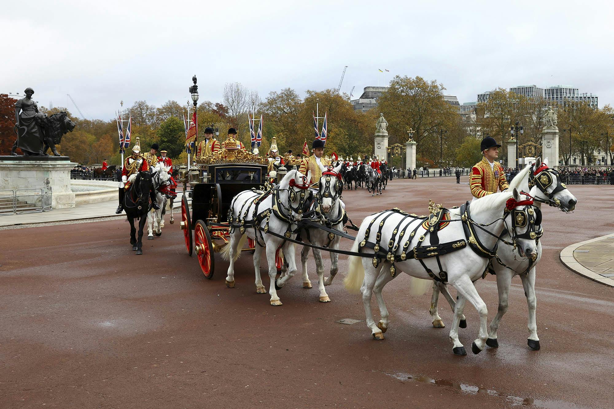 A procession with a royal carriage returns to Buckingham palace after a welcome ceremony for South Korea's President Yoon Suk Yeol on the occasion of his three-day state visit to the UK, in London, Tuesday, Nov. 21, 2023. (Hannah McKay/Pool Photo via AP)