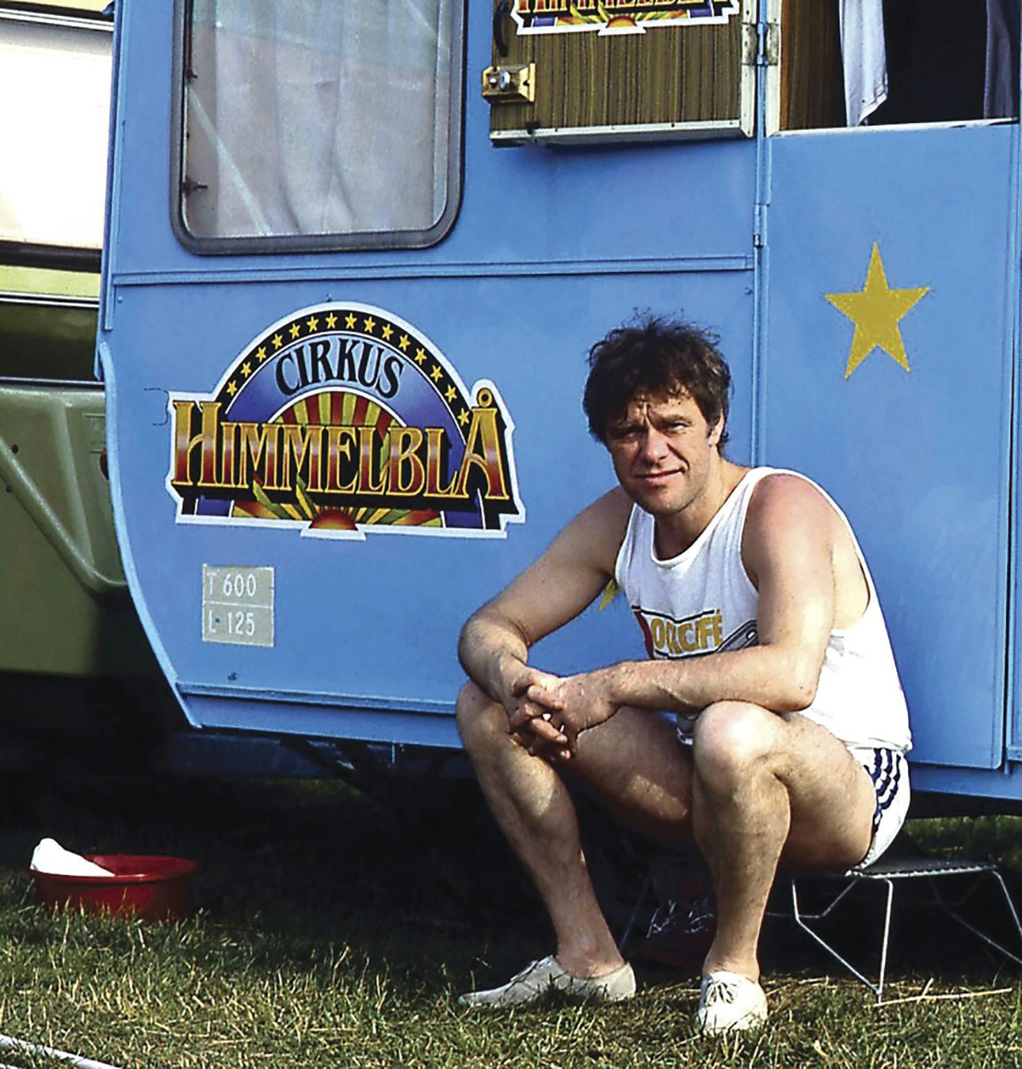 Sanger Kim Larsen ved en blå campingvogn med "Cirkus Himmelblå" - Dato: udateret arkivbillede fra 1985 - Foto: Winnifred Eriksen