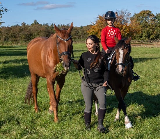 Mascha Vang med sin hest Catchmo og datteren Hollie, der rider på sin pony Rondo.