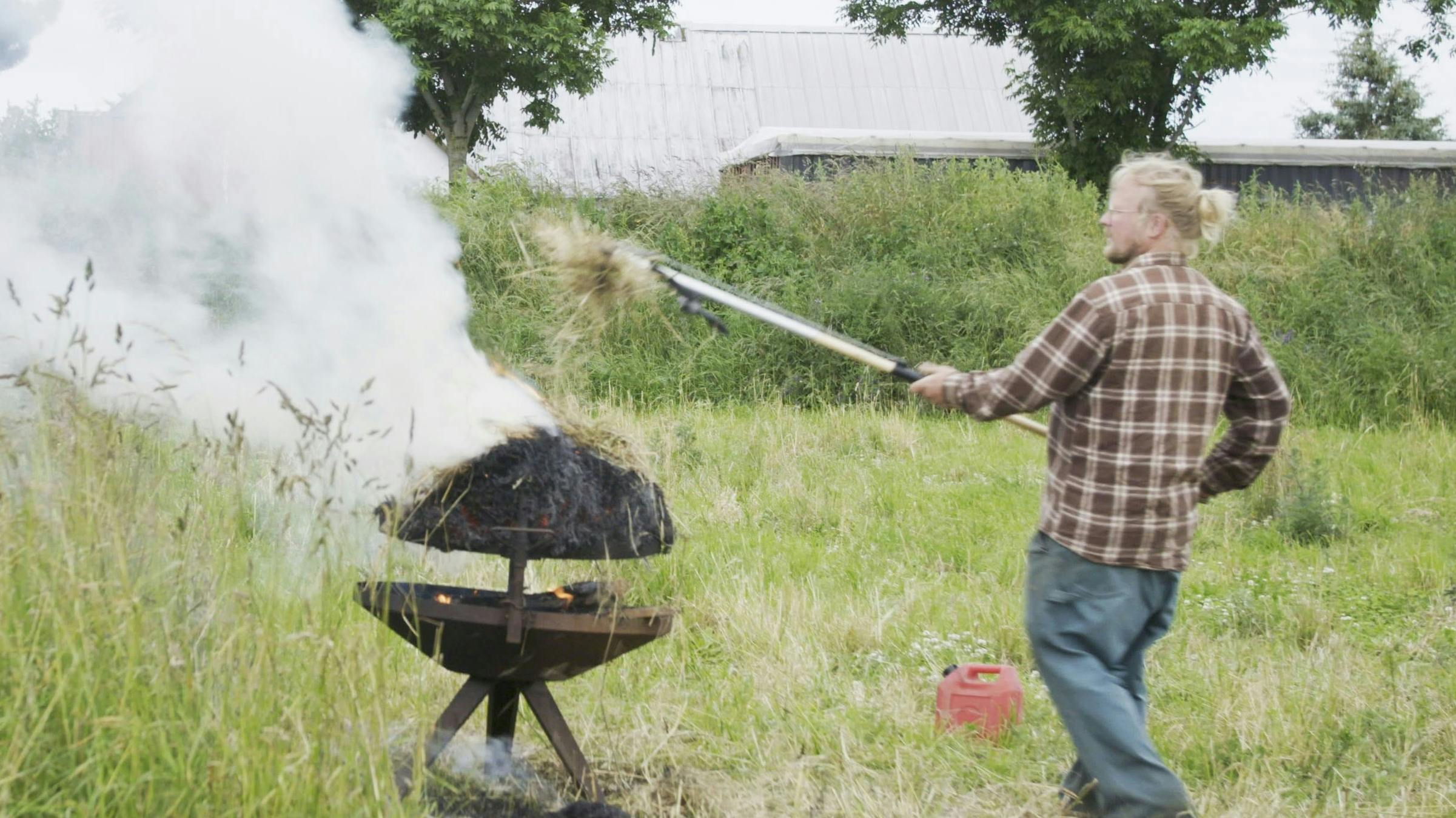 Markus Hvass i gang ved grillen med at brænde halm af.