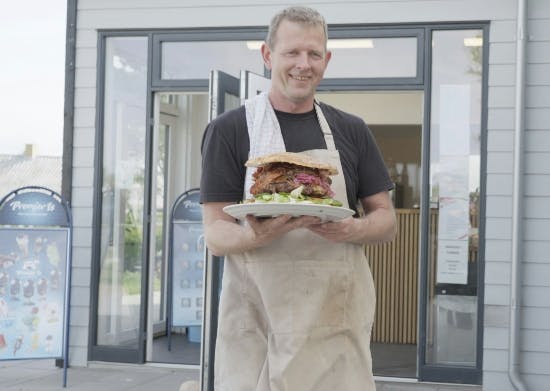 Simon Larsen i sit Minigolf-land, hvor man kan få en burger på over tre kilo.