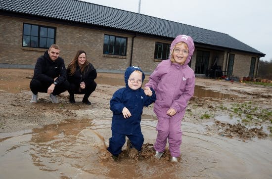 Nalina og lillebror Noor hopper i mudderpytter.