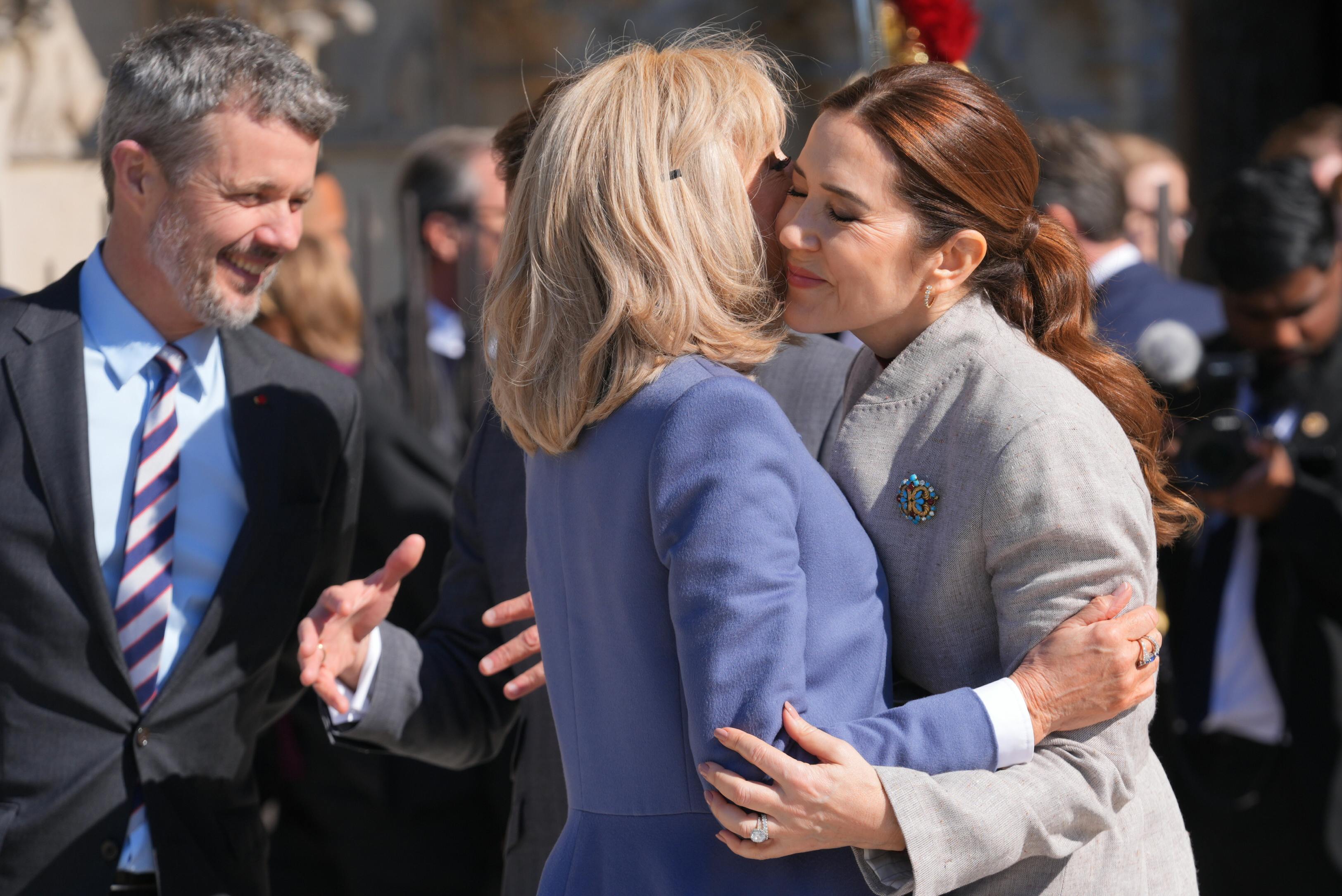Dronning Mary og Brigitte Macron hilser på hinanden.