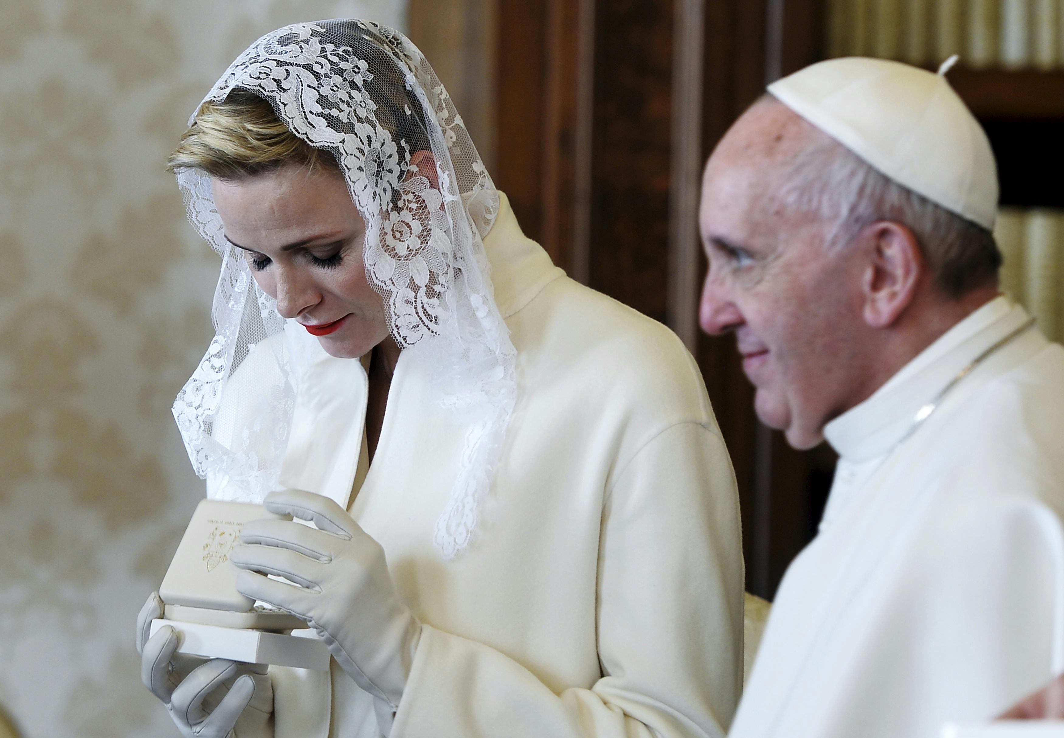 Princess Charlene (L) exchanges gifts with Pope Francis during a private audience with her husband Prince Albert II of Monaco (unseen) at the Vatican, January 18, 2016. REUTERS/Filippo Monteforte/Pool TPX IMAGES OF THE DAY
