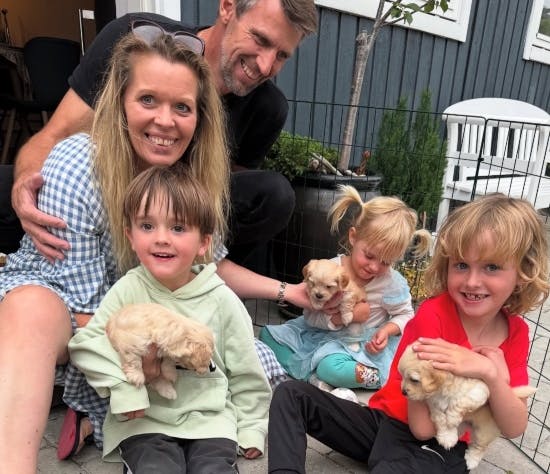 Ini og Anders med Lucas, Noah og Aura, der holder hver sin hundehvalp. 