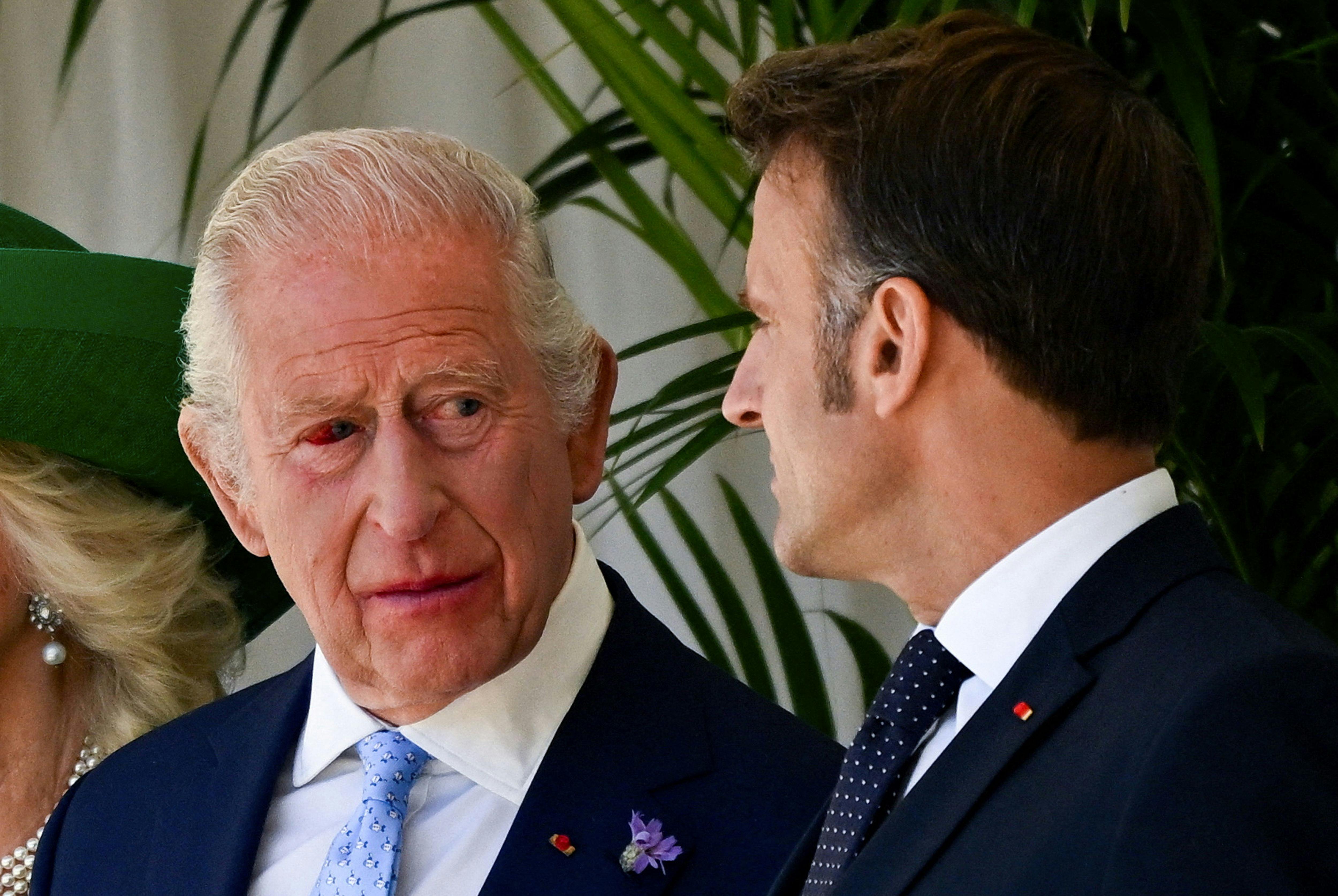 France's President Emmanuel Macron (R) talks to Britain's King Charles III, who's eye is red, during a ceremonial welcome at Windsor Castle, in Windsor west of London, on July 8, 2025, on the first day of a three-day state visit to Britain. French President Emmanuel Macron began a three-day state visit to Britain on Tuesday, which will see him address parliament and try to rekindle a purportedly warm relationship with King Charles III. (Photo by Dylan Martinez / POOL / AFP)