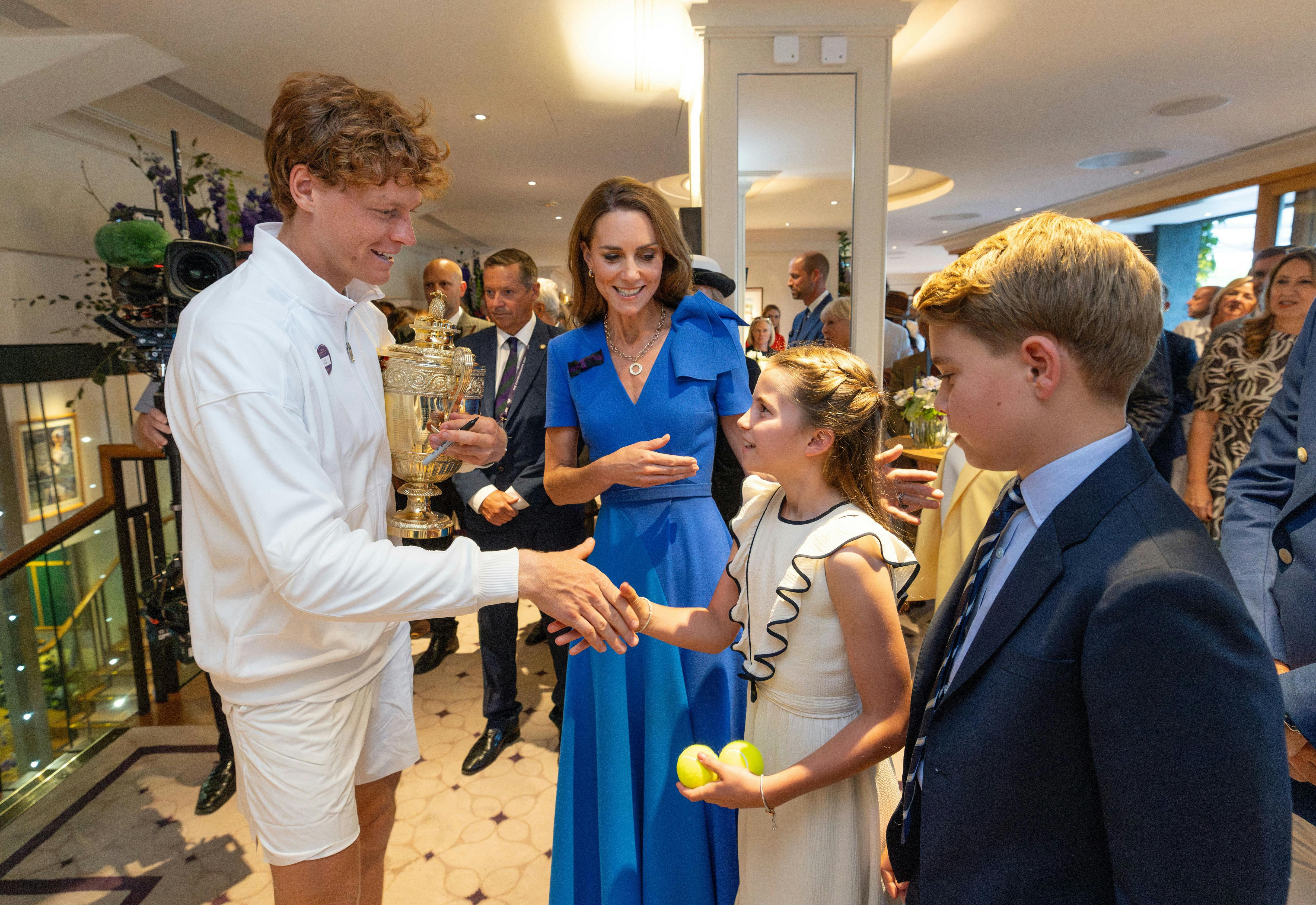 Tennis - Wimbledon - All England Lawn Tennis and Croquet Club, London, Britain - July 13, 2025 Italy's Jannik Sinner with the trophy alongside Britain's Catherine, Princess of Wales, Princess Charlotte and Prince George after winning the men's final against Spain's Carlos Alcaraz Pool via Reuters/Andrew Parsons