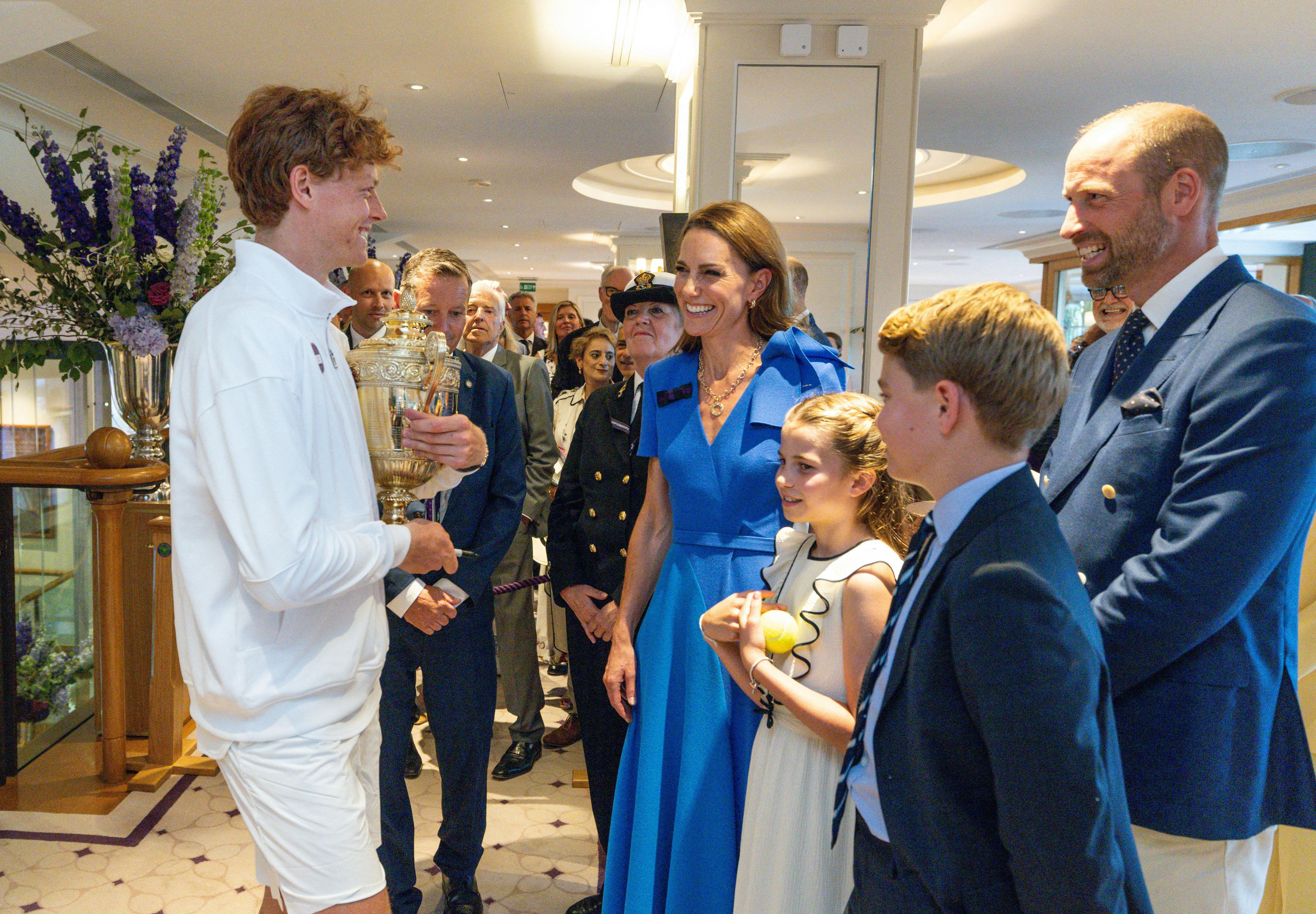 Tennis - Wimbledon - All England Lawn Tennis and Croquet Club, London, Britain - July 13, 2025 Italy's Jannik Sinner with the trophy alongside Britain's Catherine, Princess of Wales, Prince William with their children Princess Charlotte and Prince George after winning the men's final against Spain's Carlos Alcaraz Pool via Reuters/Andrew Parsons