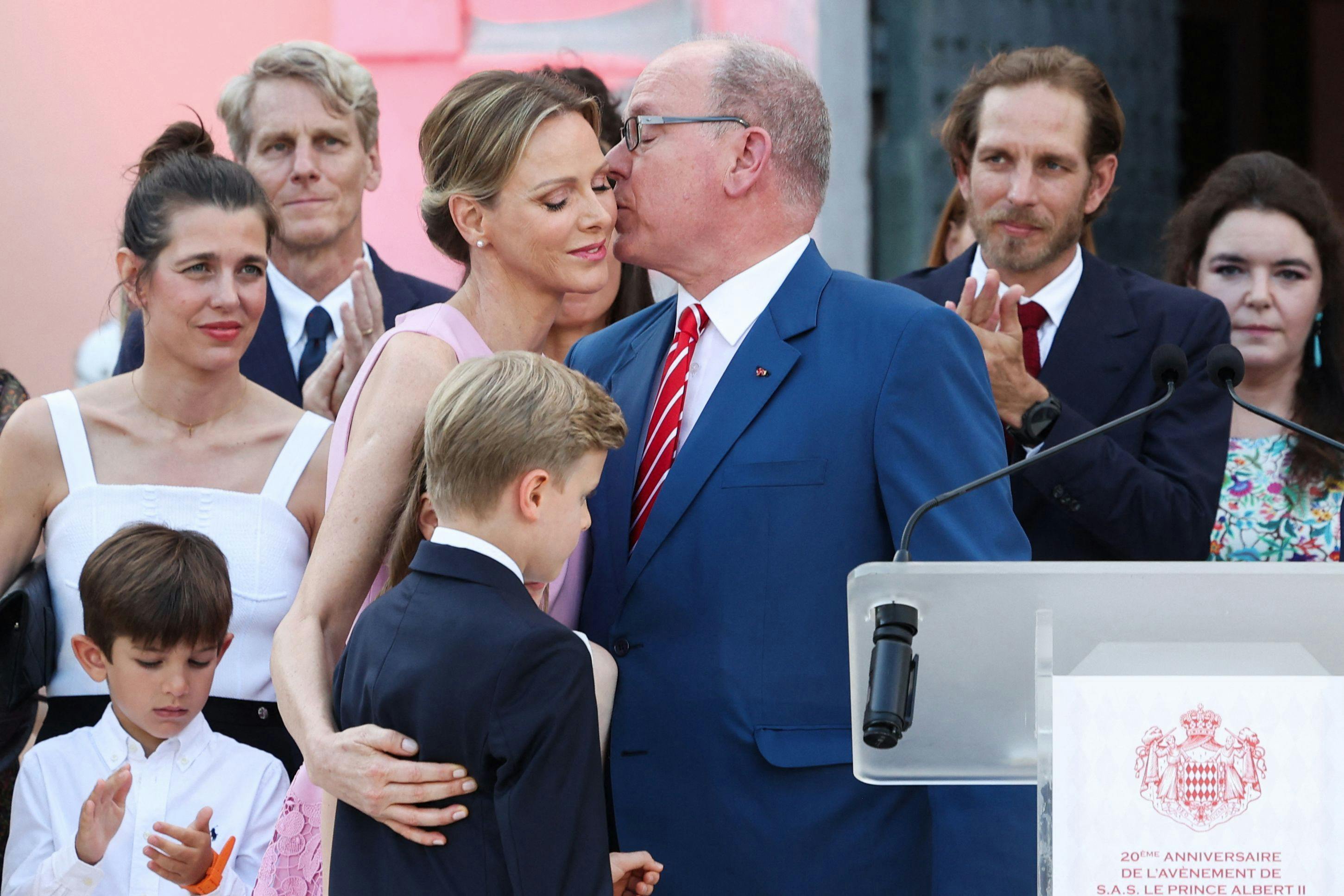 Albert II of Monaco kisses Charlene of Monaco near son and twin to Gabriella Jacques Grimaldi as they arrive to attend the 20th anniversary of the accession of Prince Albert II in Monaco, on July 19, 2025. (Photo by Valery HACHE / AFP) / NO TABLOIDS WEB & PRINT, NO DAILY MAIL, NO DAILY MAIL GROUP (DMGT), NO VOICI, NO CLOSER